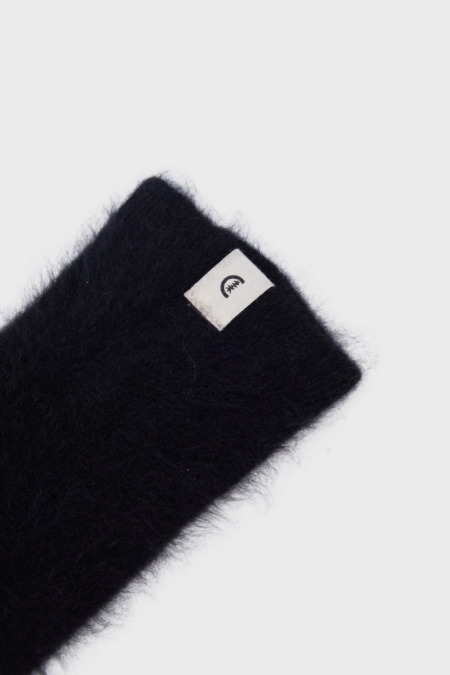 Close-up of the soft texture and discreet logo tab at the wrist.