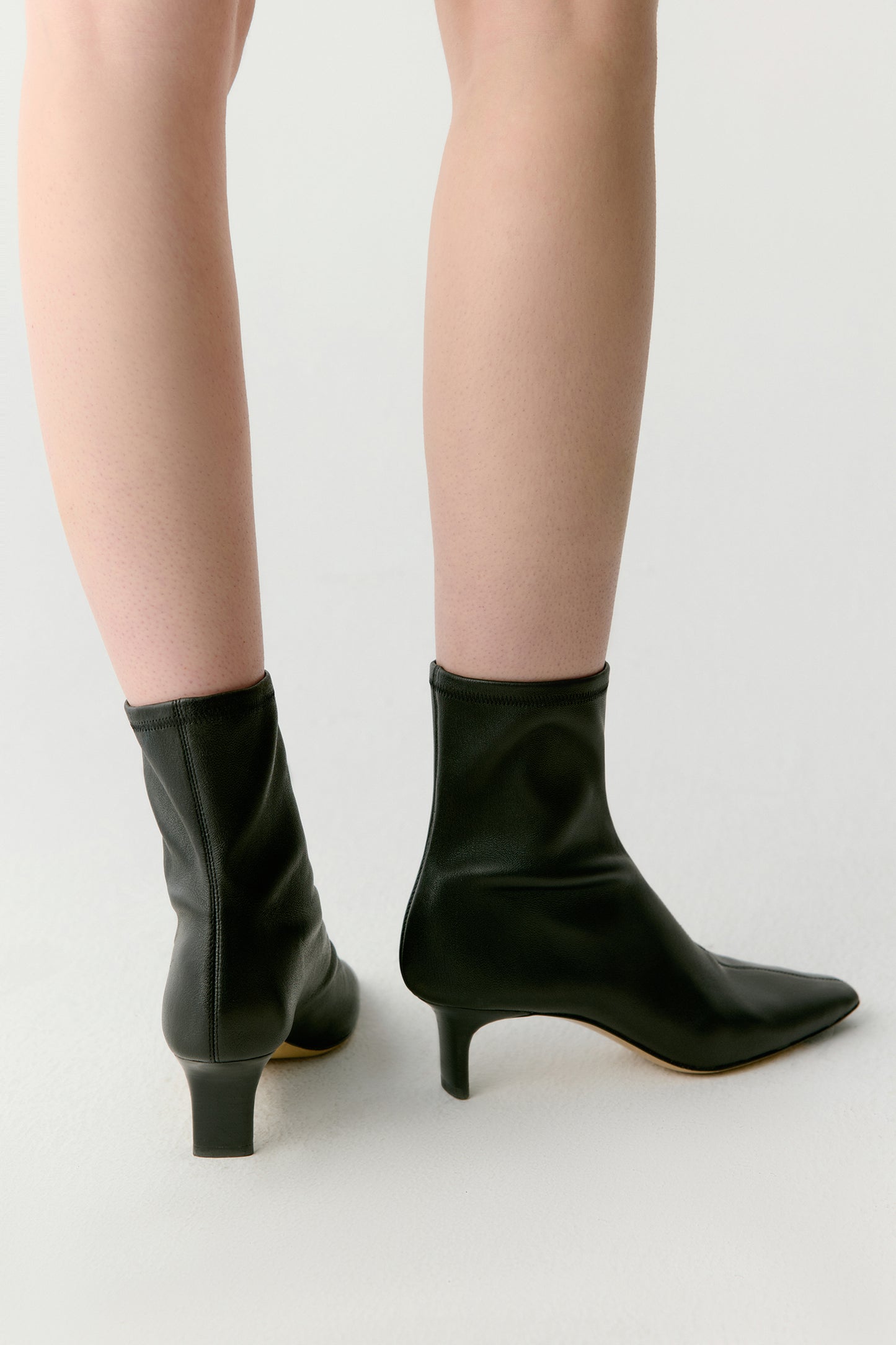 Rear angle highlighting the heel height and smooth continuity of the upper.