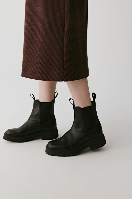 Side angle highlighting the mix of supple calf leather and ribbed knit texture.