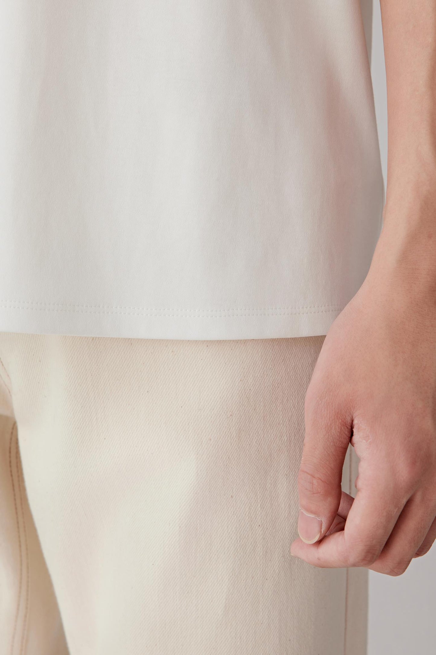 Close-up of the sleeve hem and fabric surface, highlighting the softness, breathability and refined finishing of the cotton jersey.