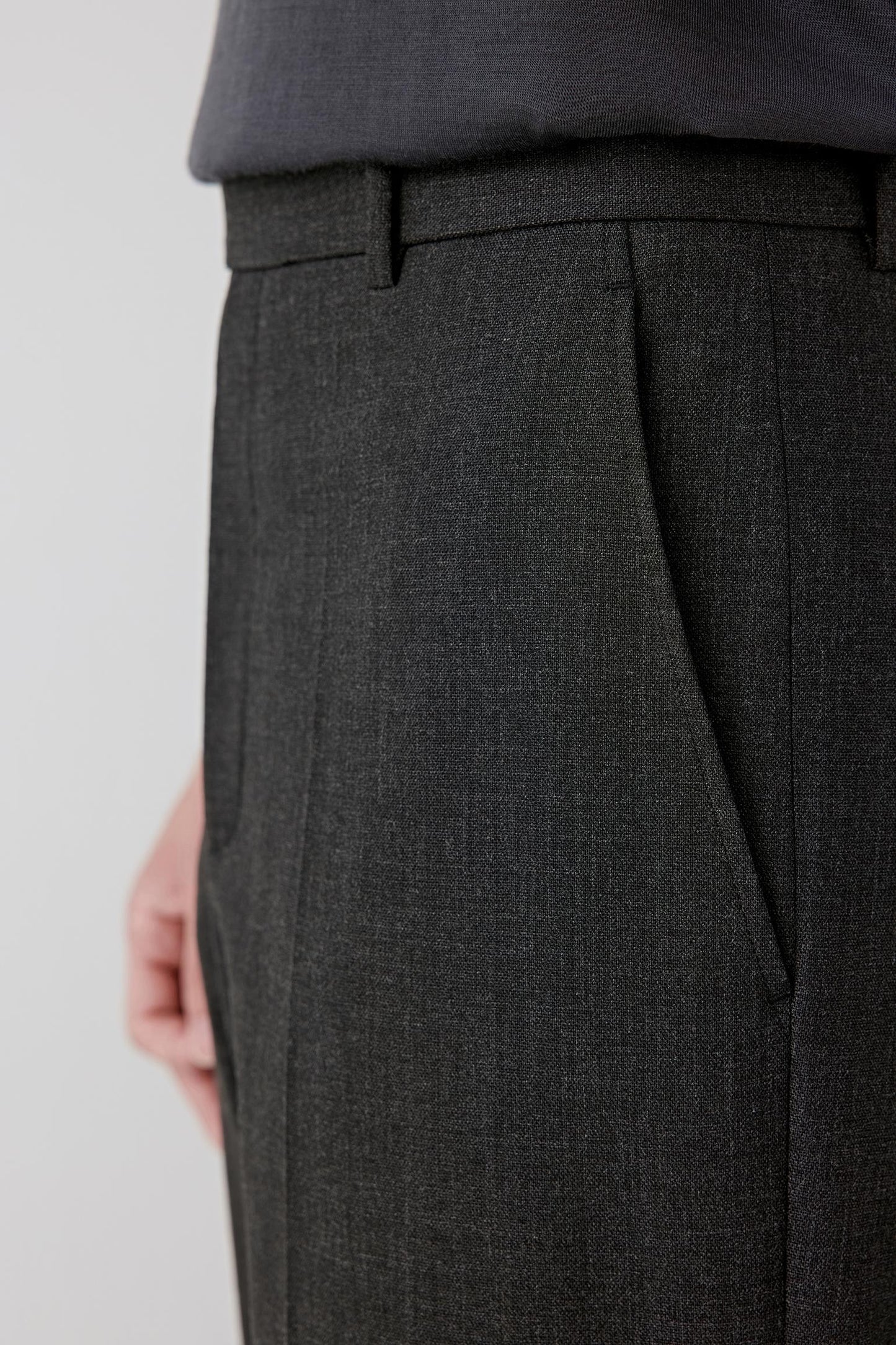 Close-up of the upper leg and hip area, revealing the fine texture of the twist wool and subtle crease line.