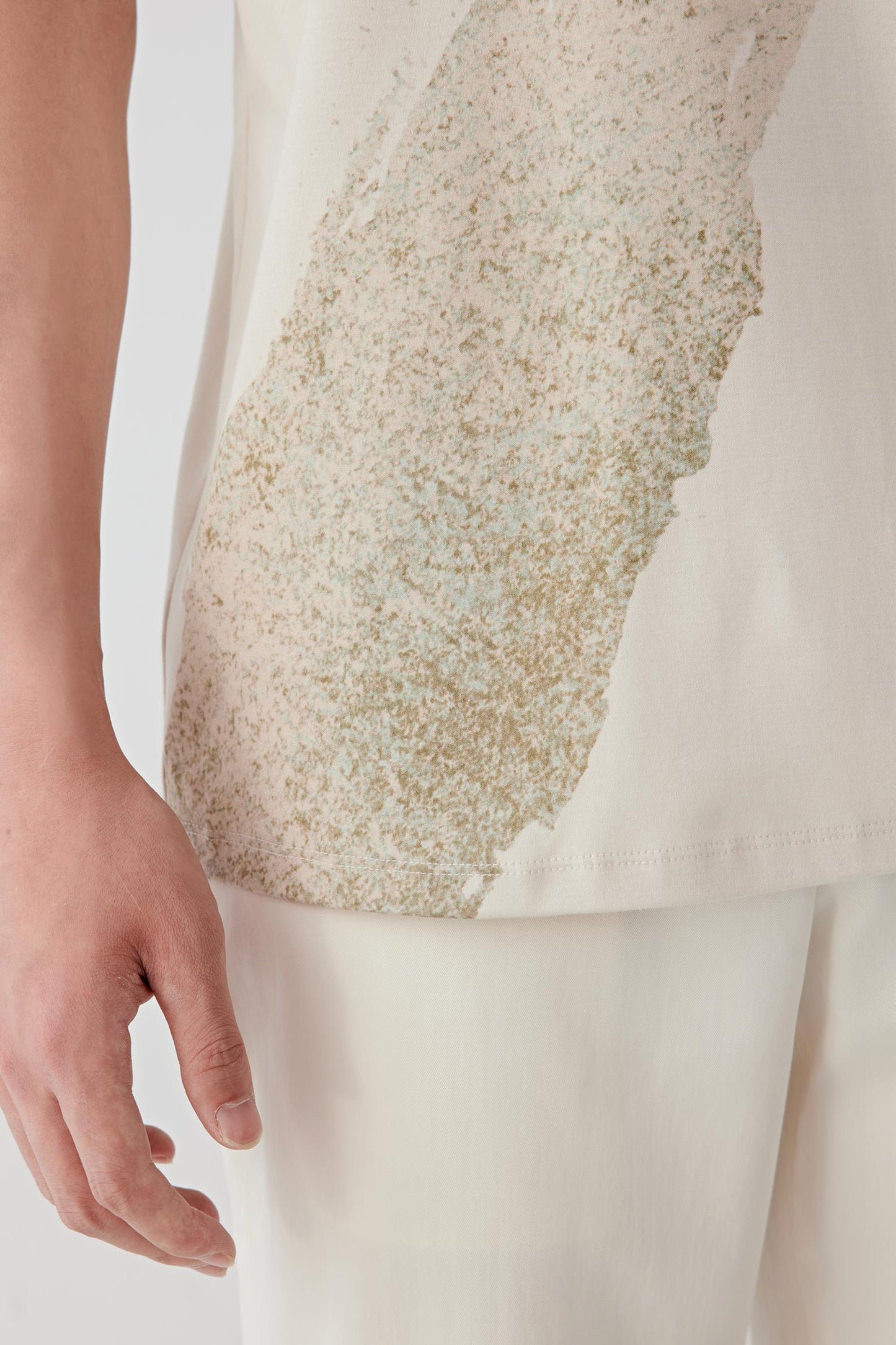 Close-up of the lower body highlighting the graphic detail placement and the smooth, dense hand feel of the cotton jersey.