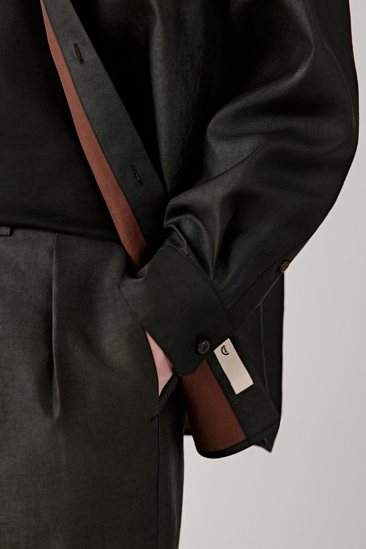 Close-up of the lower front and pocket area, showing the discreet chest pocket, natural surface variations and artisanal texture of the fabric.