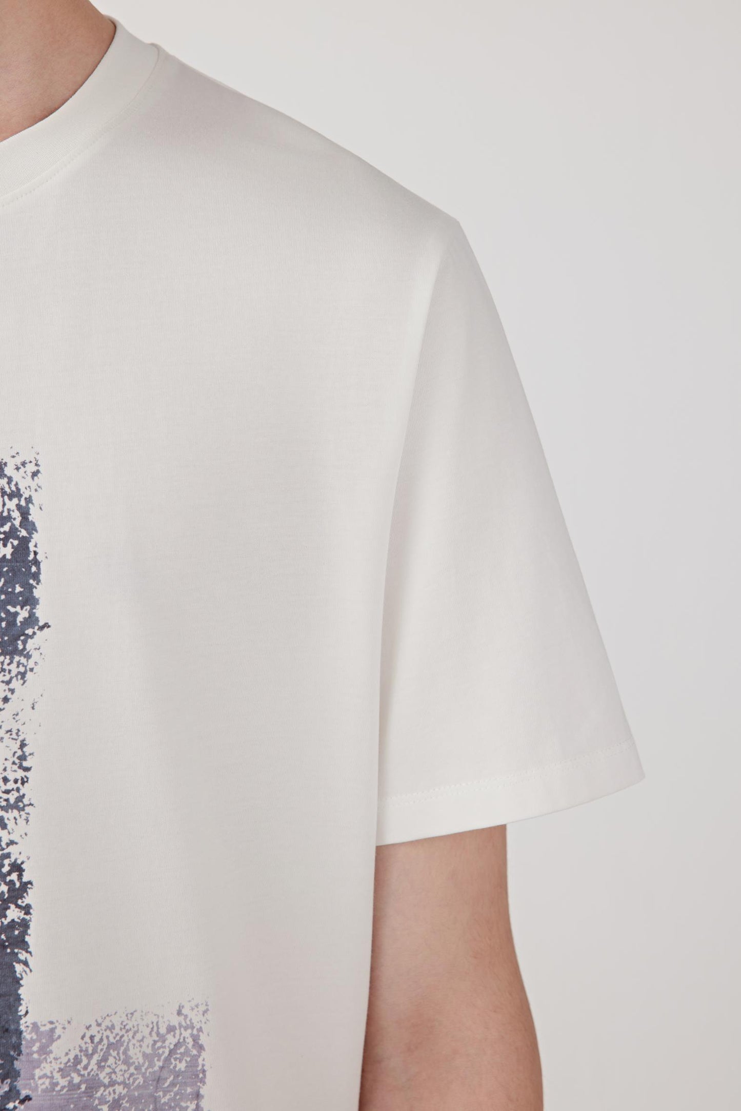 Close-up of the sleeve and shoulder highlighting the clean seams, soft cotton surface and even jersey knit.