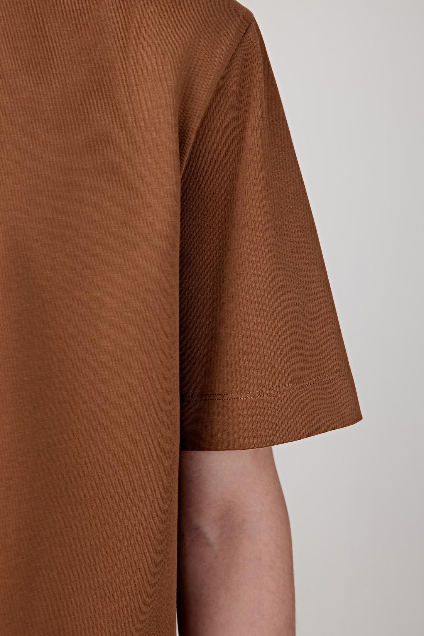 Close-up of the sleeve highlighting the clean hem finish and soft, breathable knit texture.