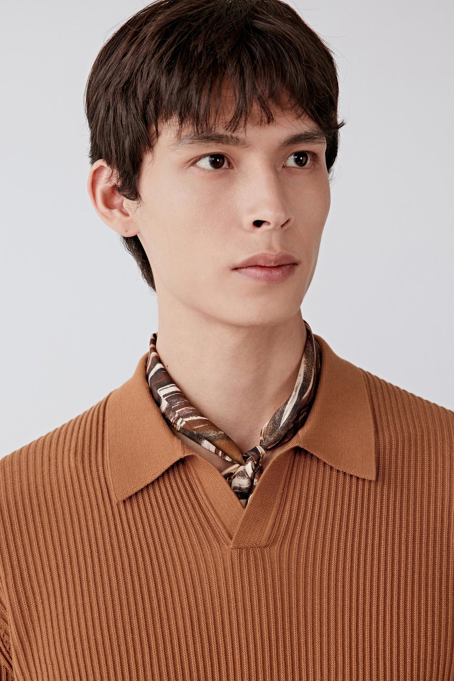 Close-up of the sleeve and upper arm, highlighting the short sleeve cut, clean finishing and the lightweight, breathable cotton knit structure with a soft, dry hand feel