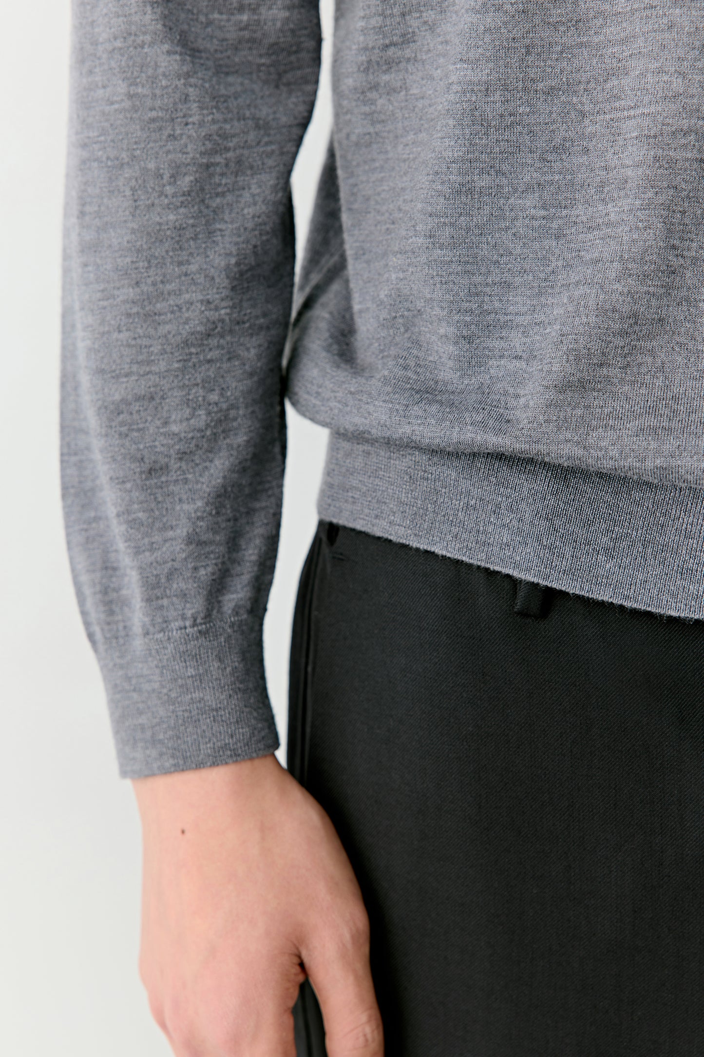 A close-up focuses on the sleeve and ribbed hem, showing fine detailing and texture precision.