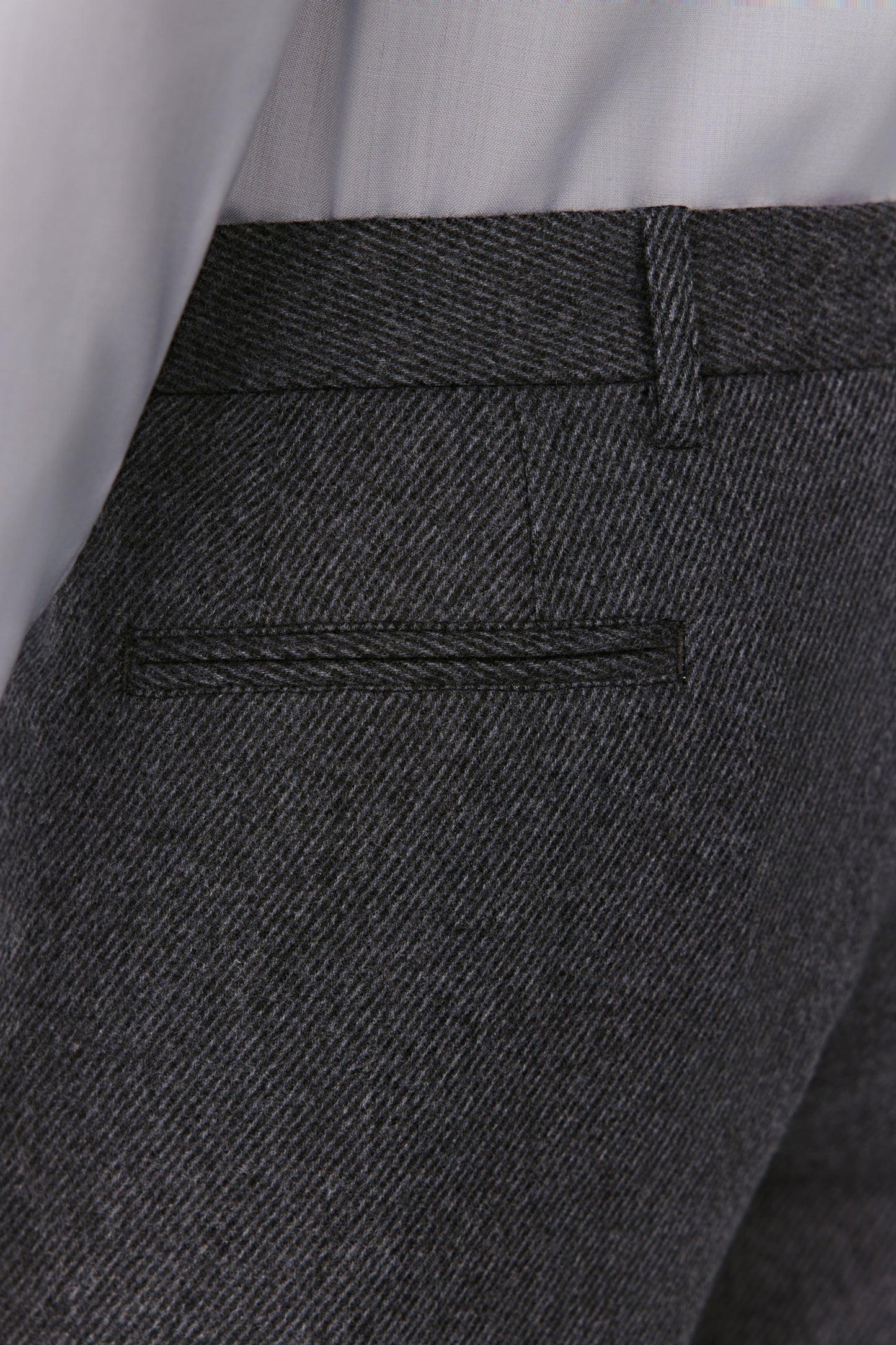 Close-up of dark gray pants with a pocket detail.