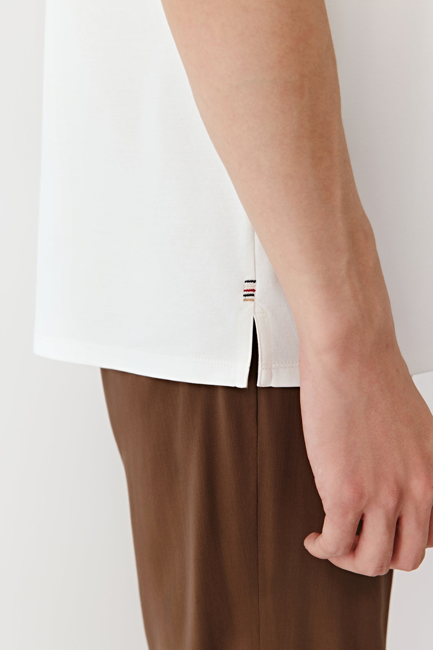 A close-up highlights the embroidered details on the side, revealing the delicate stitching and the soft contrast with the cotton.