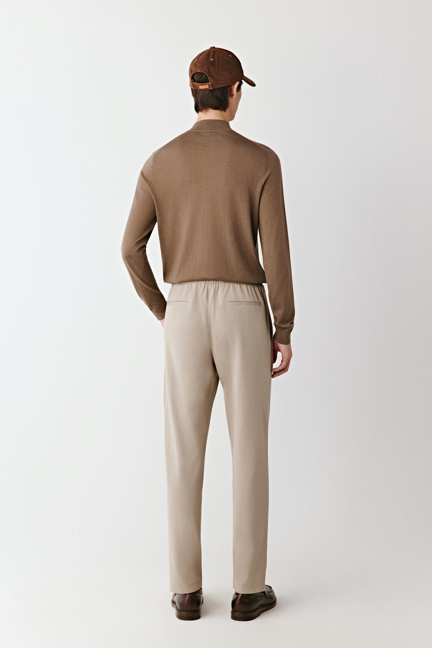 The back view shows the sweater’s clean cut and soft fit over the shoulders.