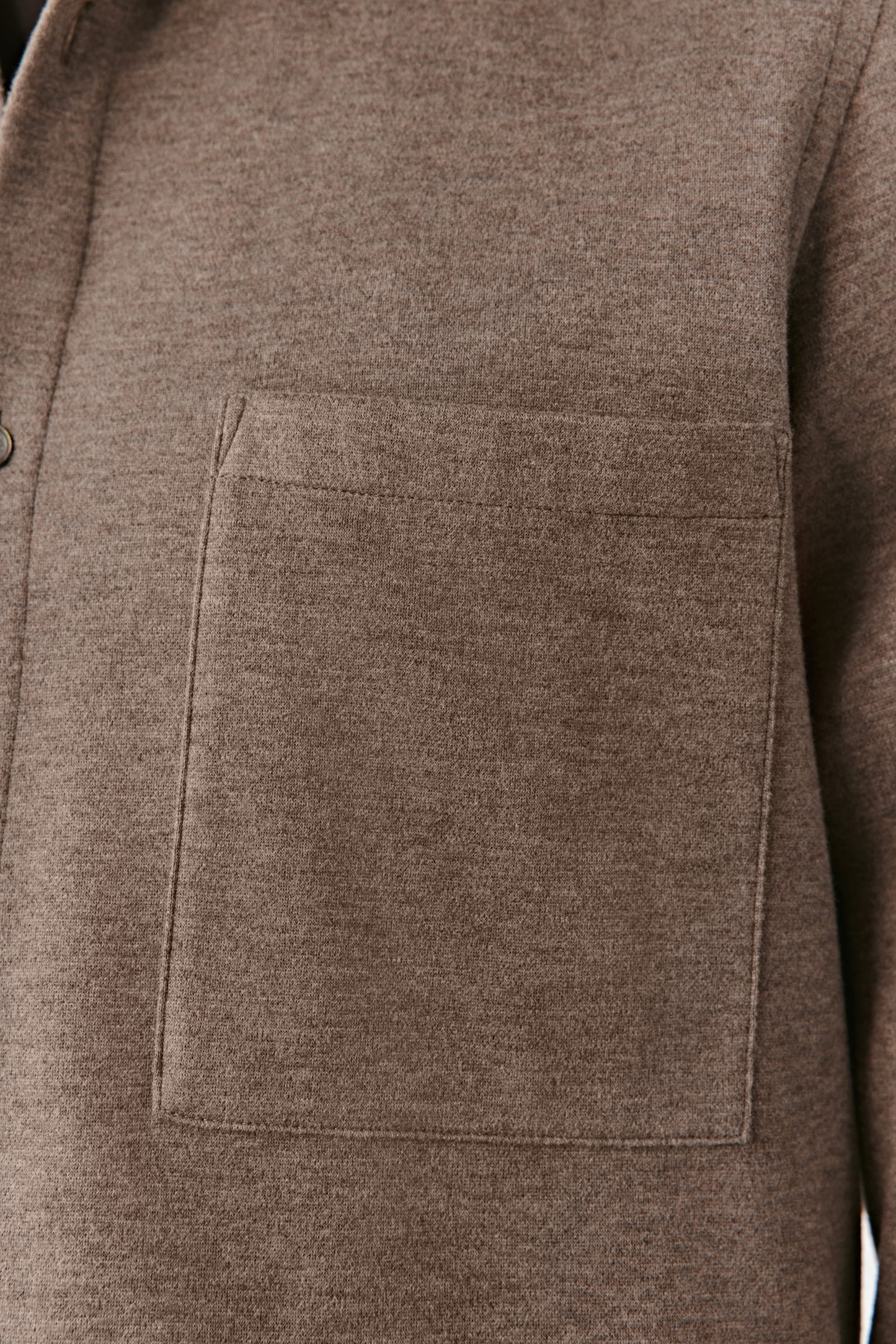 Close-up of the discreet pocket on the chest, showing the refined finish and texture of the blend.