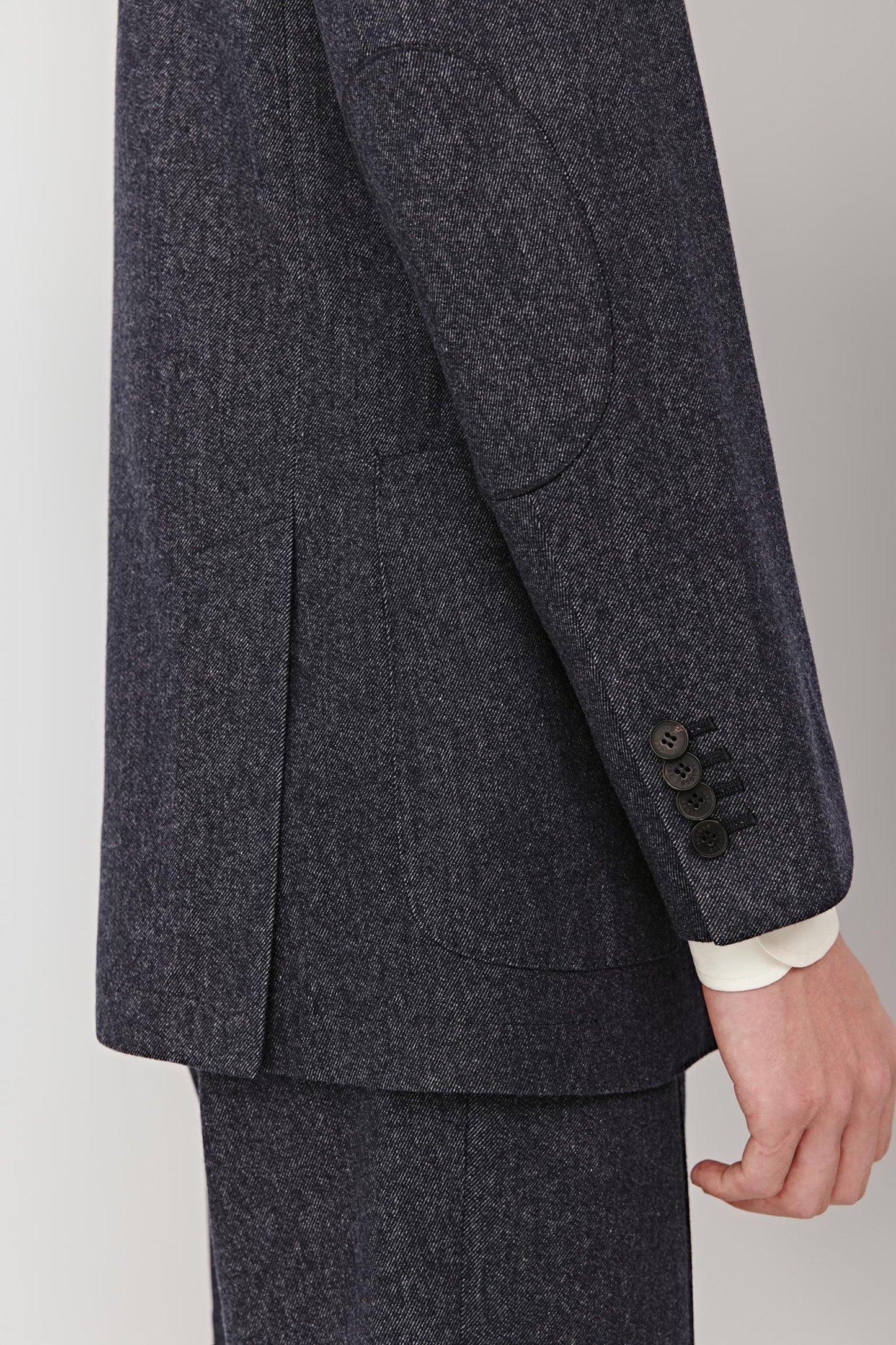 Close-up of the sleeve and pocket showing the denim-effect wool and discreet stitching.