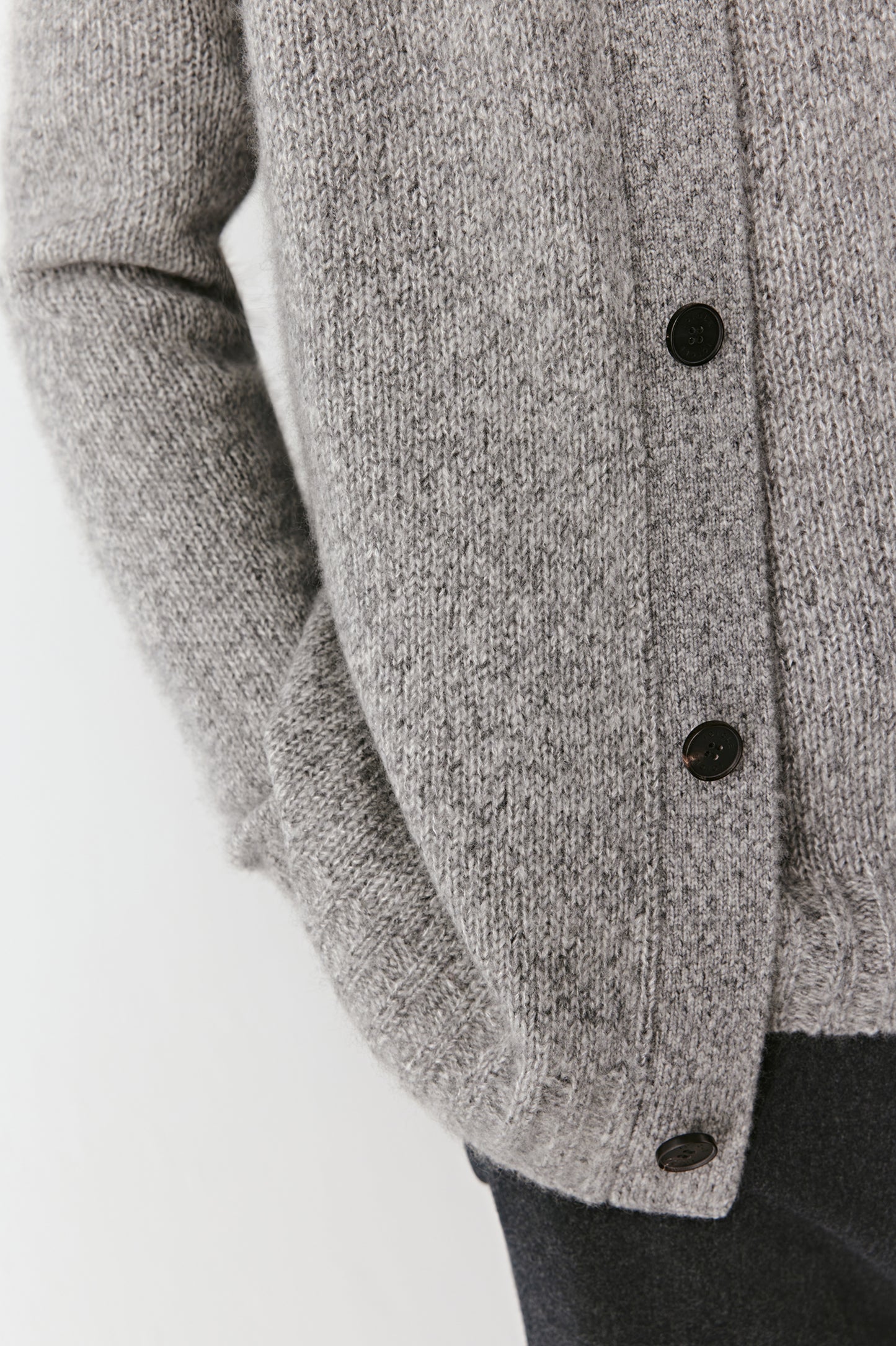 Close-up of the ribbed trims and buttons, showing the twisted yarn texture and craftsmanship.