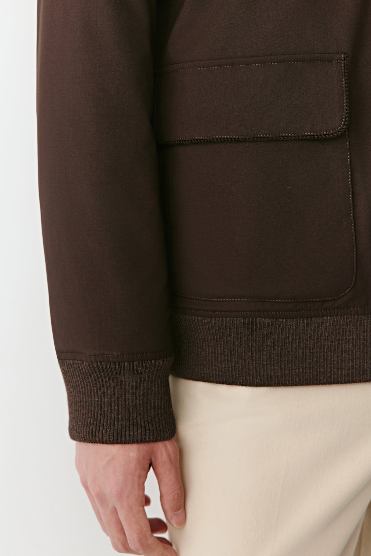 Detailed shot of the flap pocket and fabric texture of the wool and yak jacket, showing the blend’s natural sheen and craftsmanship.