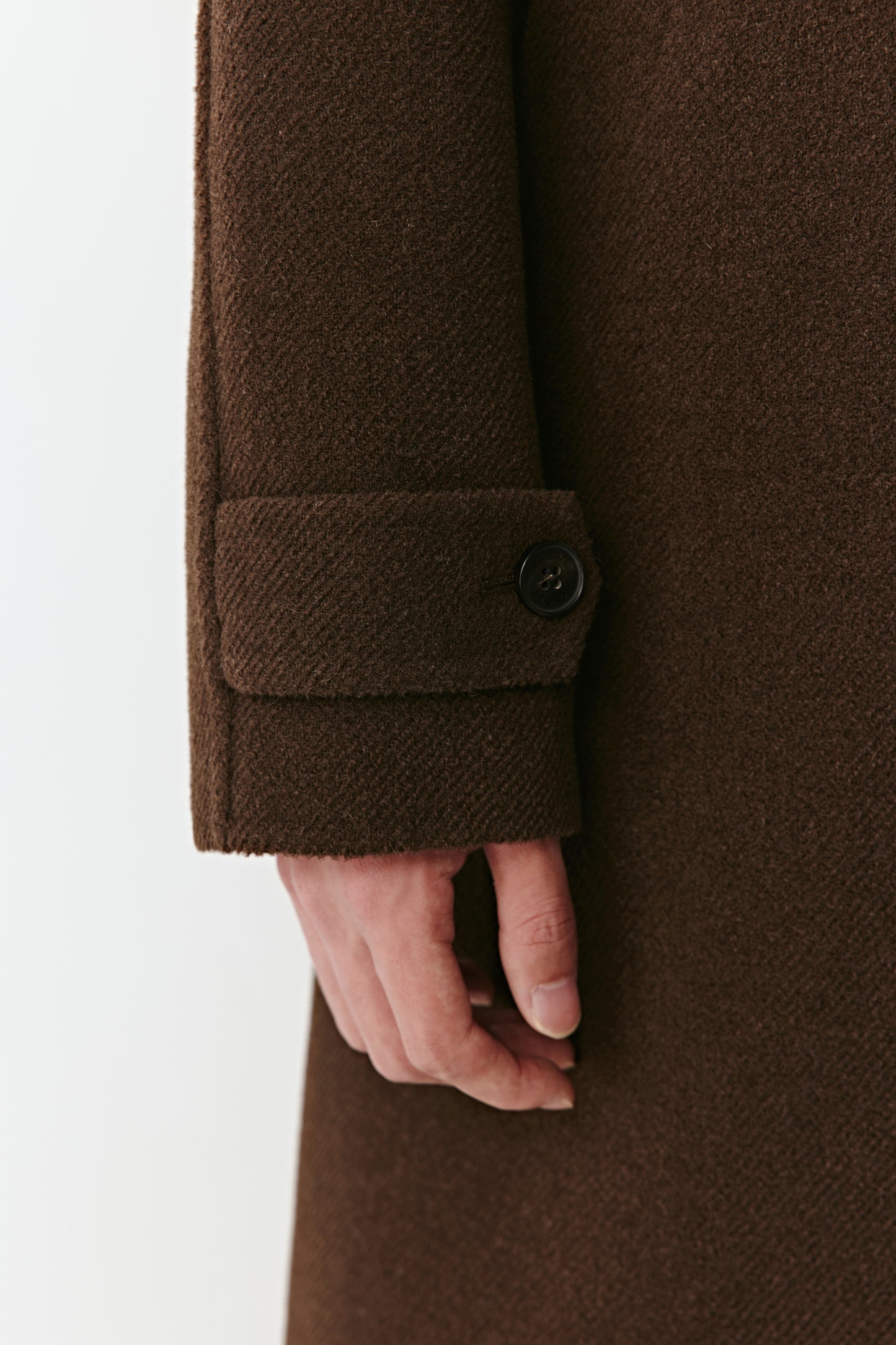 Detail shot of the chestnut-brown yak wool fabric and buttons, showing the double-faced texture and high-quality finish.