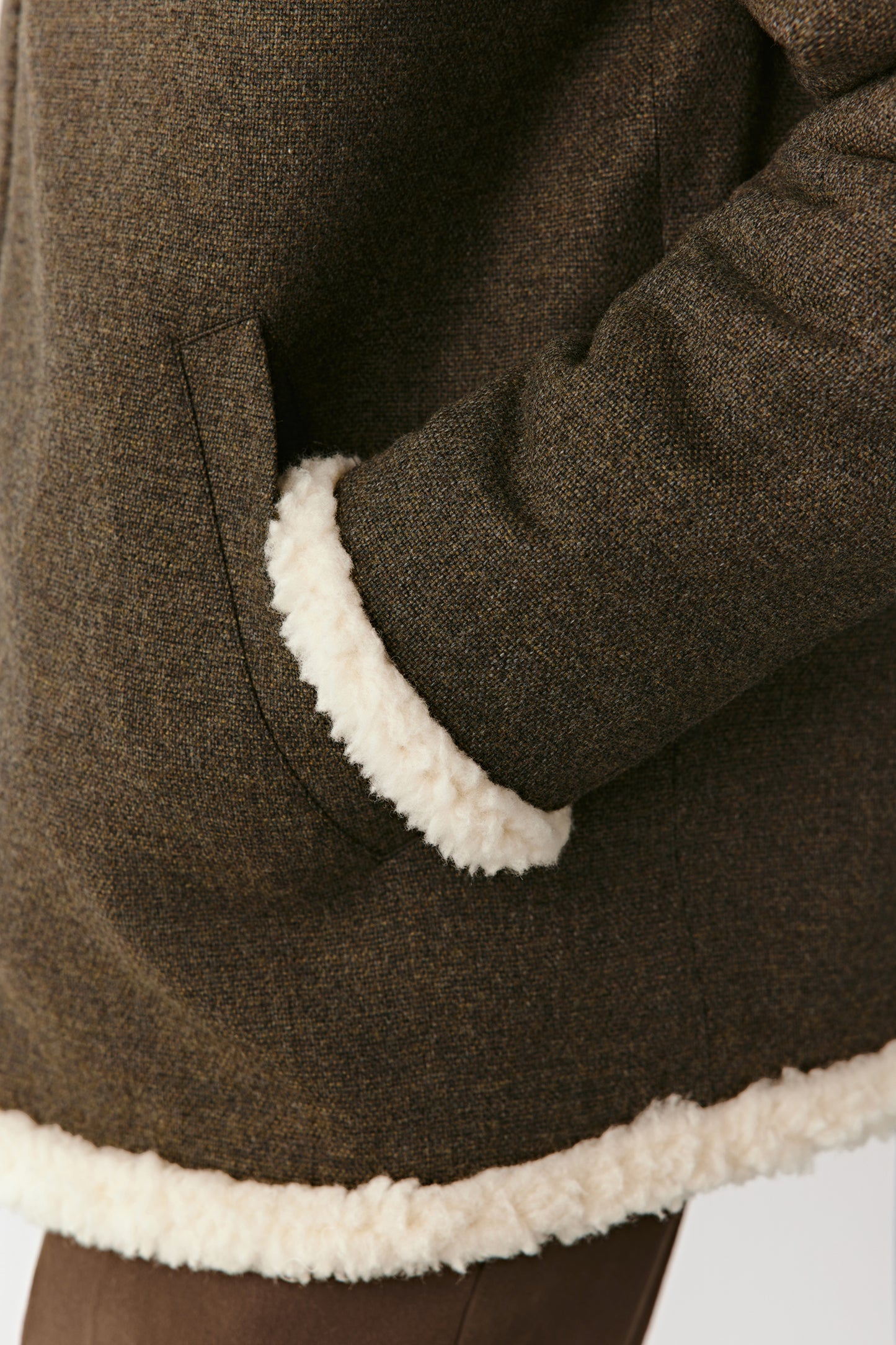 Detail shot of the wool and cashmere fabric with contrast trim, revealing the craftsmanship and plush finish.