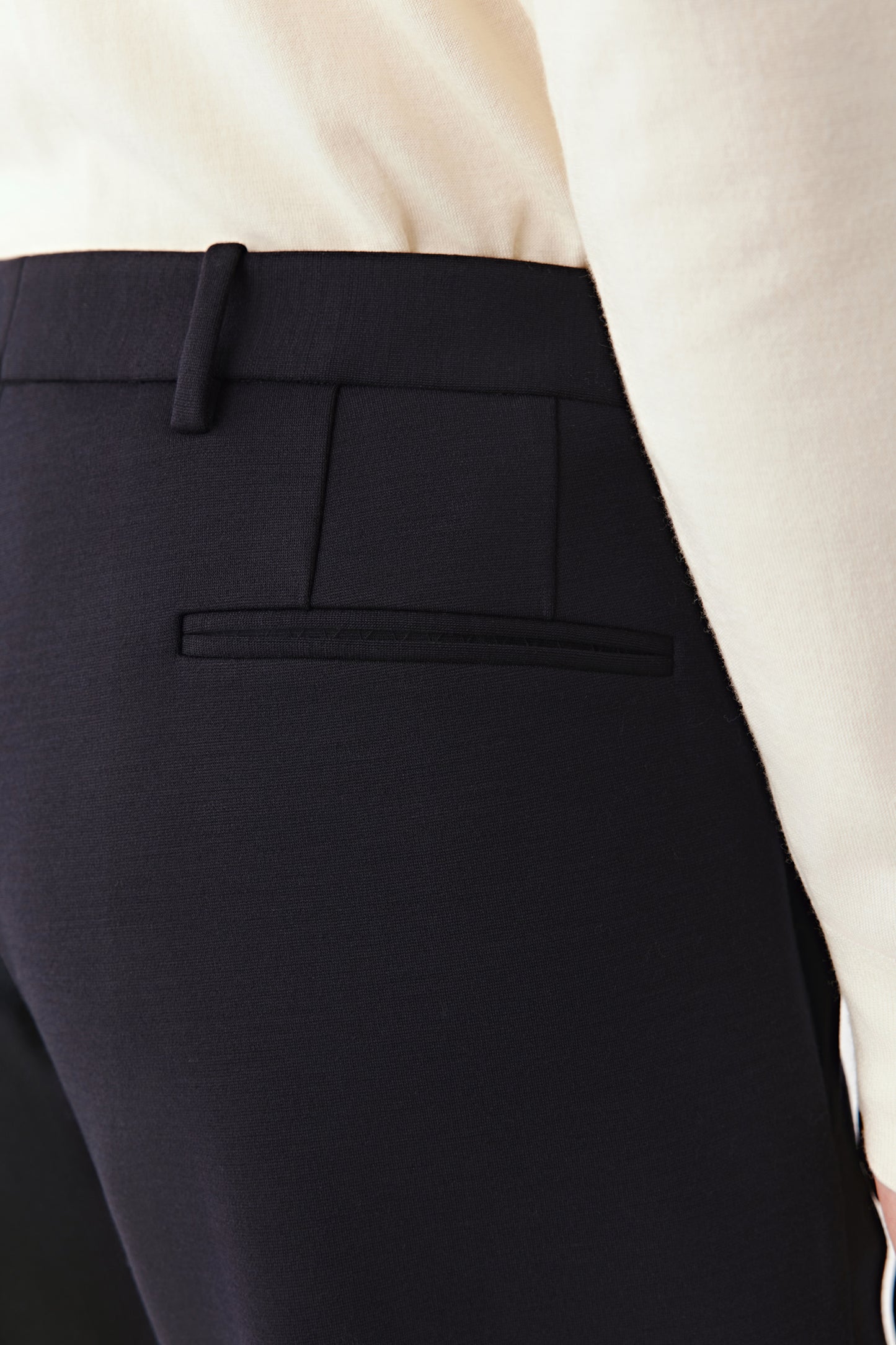 Rear view showing the single welt pocket and structured finish of the waistband.