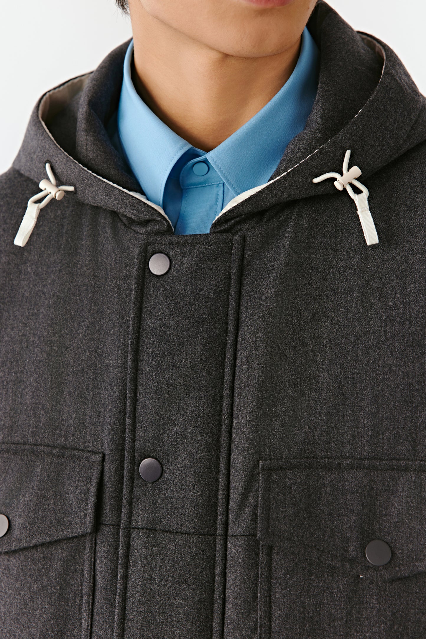 Close-up revealing the details of the hood, matte buttons and quilted stitching.