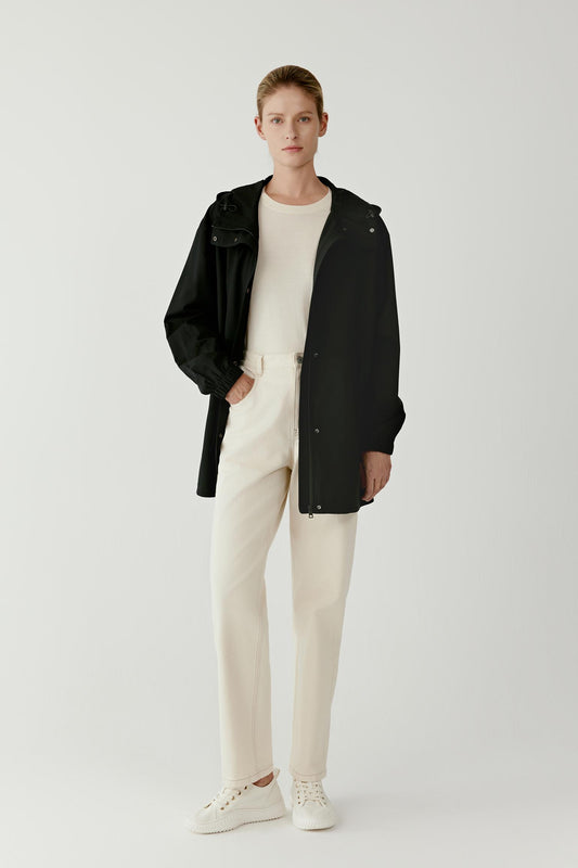 Front view of the short black trench coat showing the loose silhouette, high collar and wide sleeves.