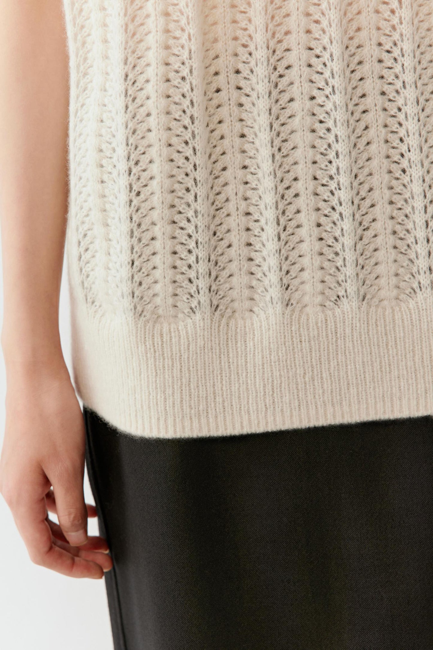 Close-up of the hem and fabric texture, showing refined finishing and soft yarn.