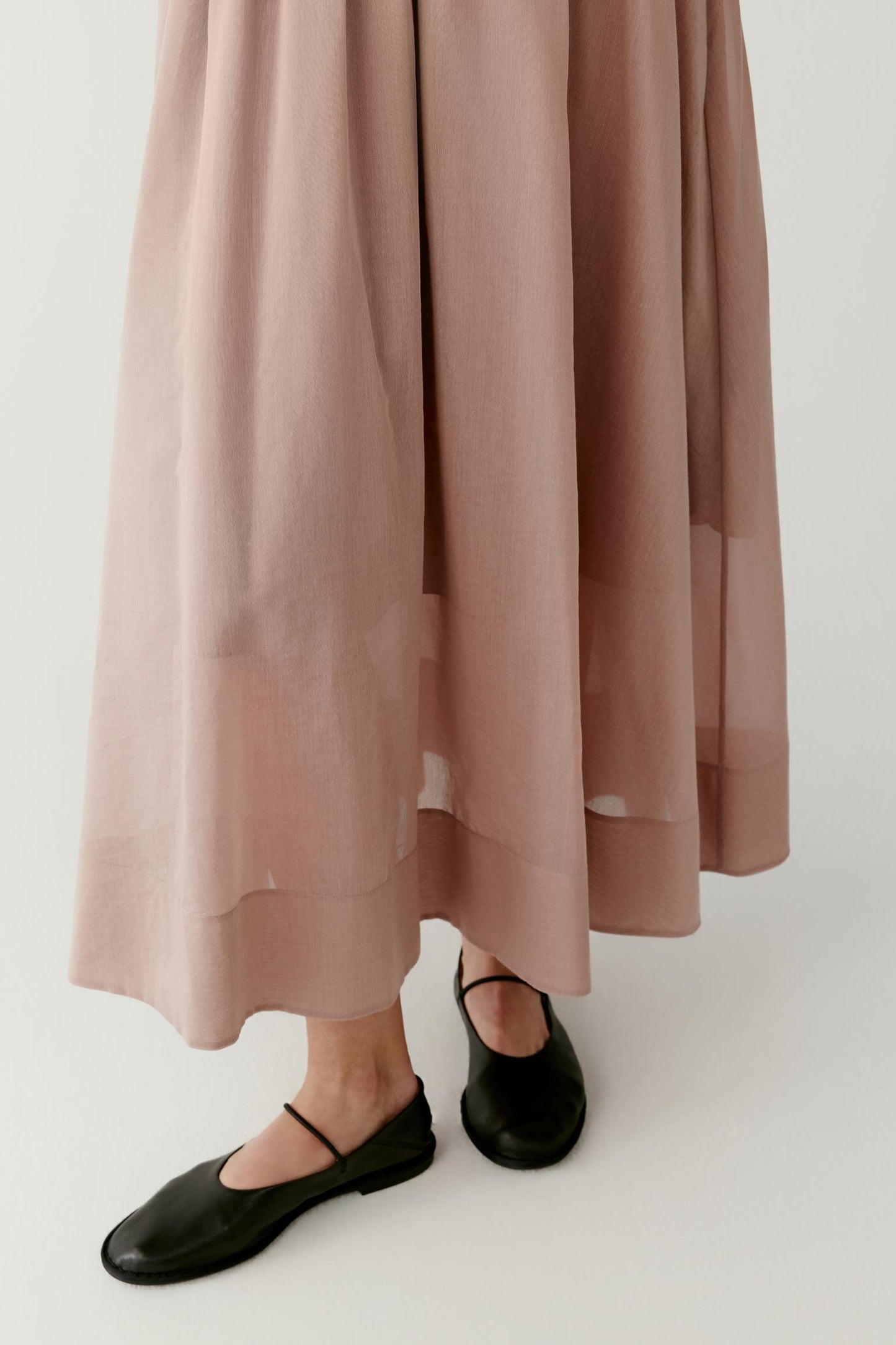 Close-up of the lower skirt and hem showing the fine texture, soft structure and smooth, flowing finish of the fabric