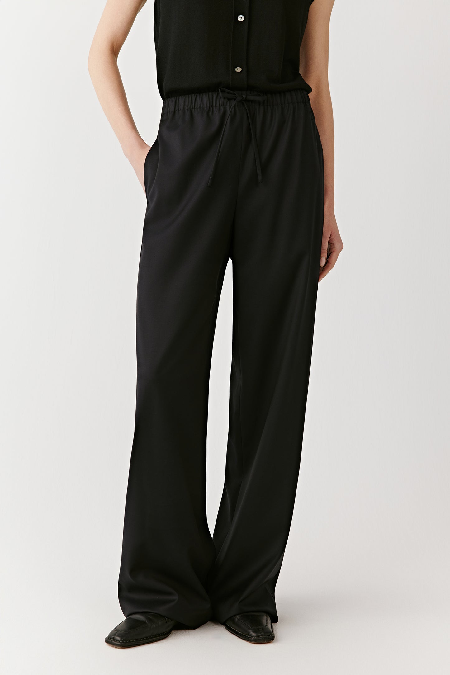 A side view shows the fluid movement of the trousers and their relaxed silhouette.