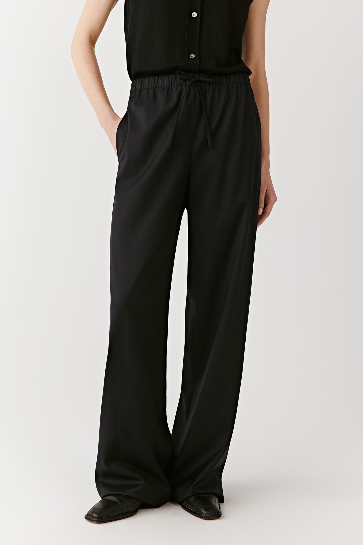 A side view shows the fluid movement of the trousers and their relaxed silhouette.