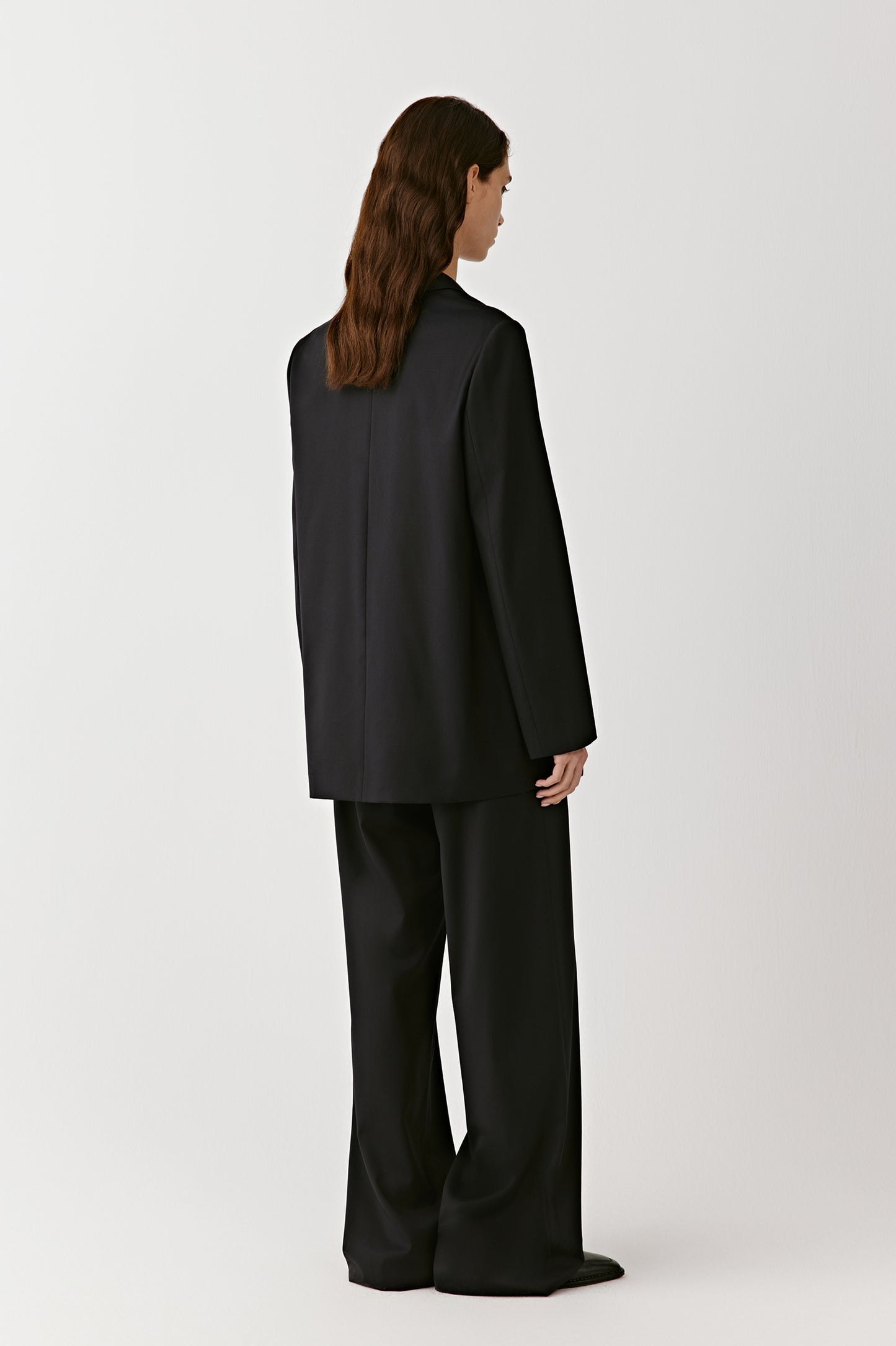 A rear view reveals the structure of the lapel and the clean lines of the cut.