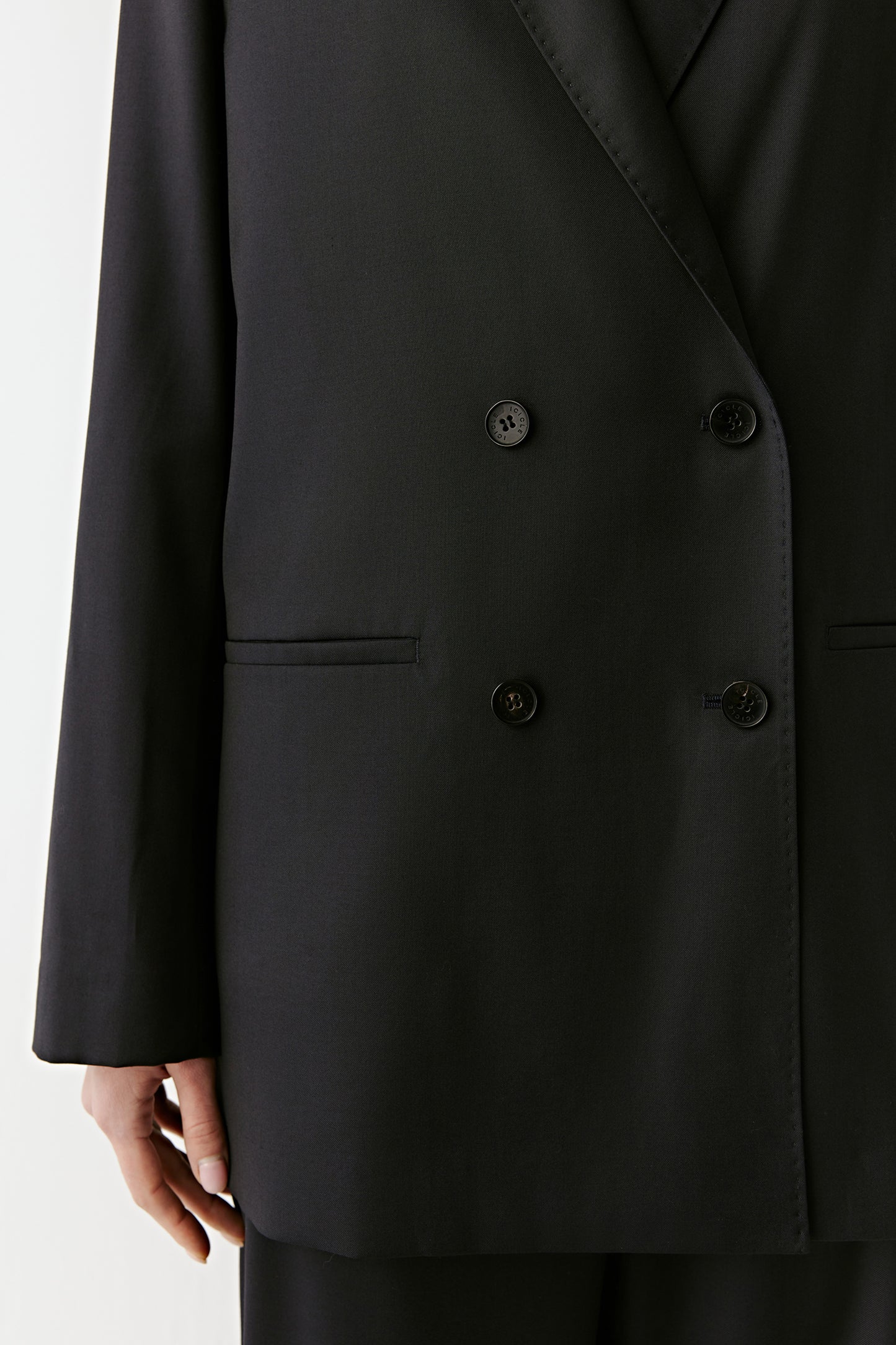 A close-up highlights the buttons on the front and the details of the pockets, emphasising the craftsmanship.