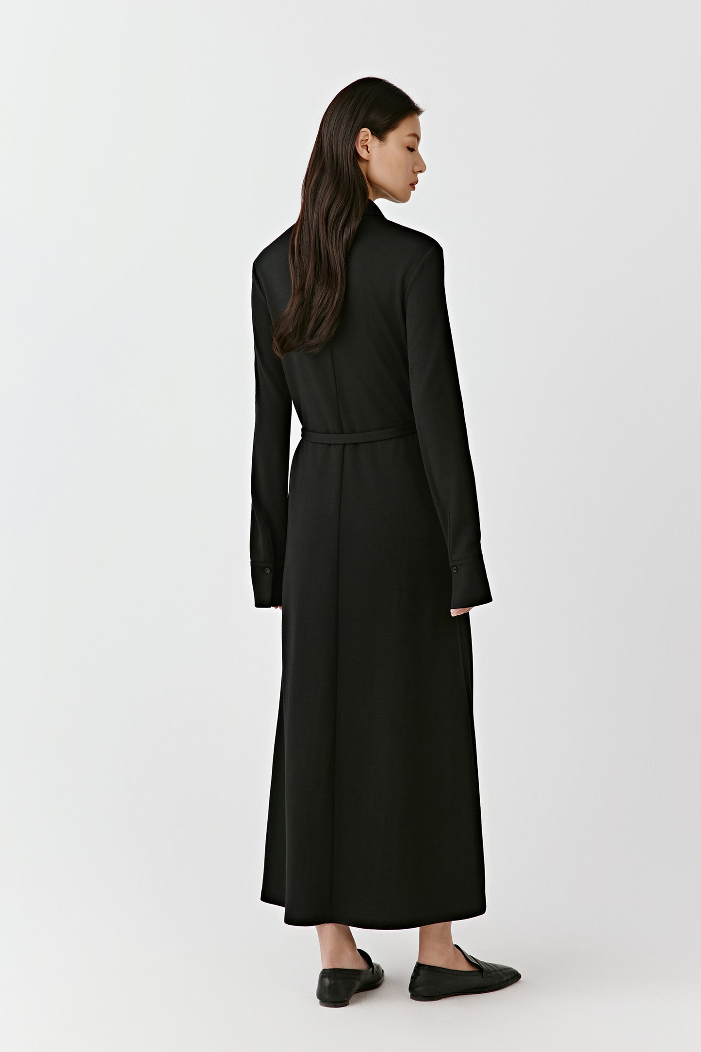 The profile view highlights the belt, which accentuates the waist and the dress's movement.