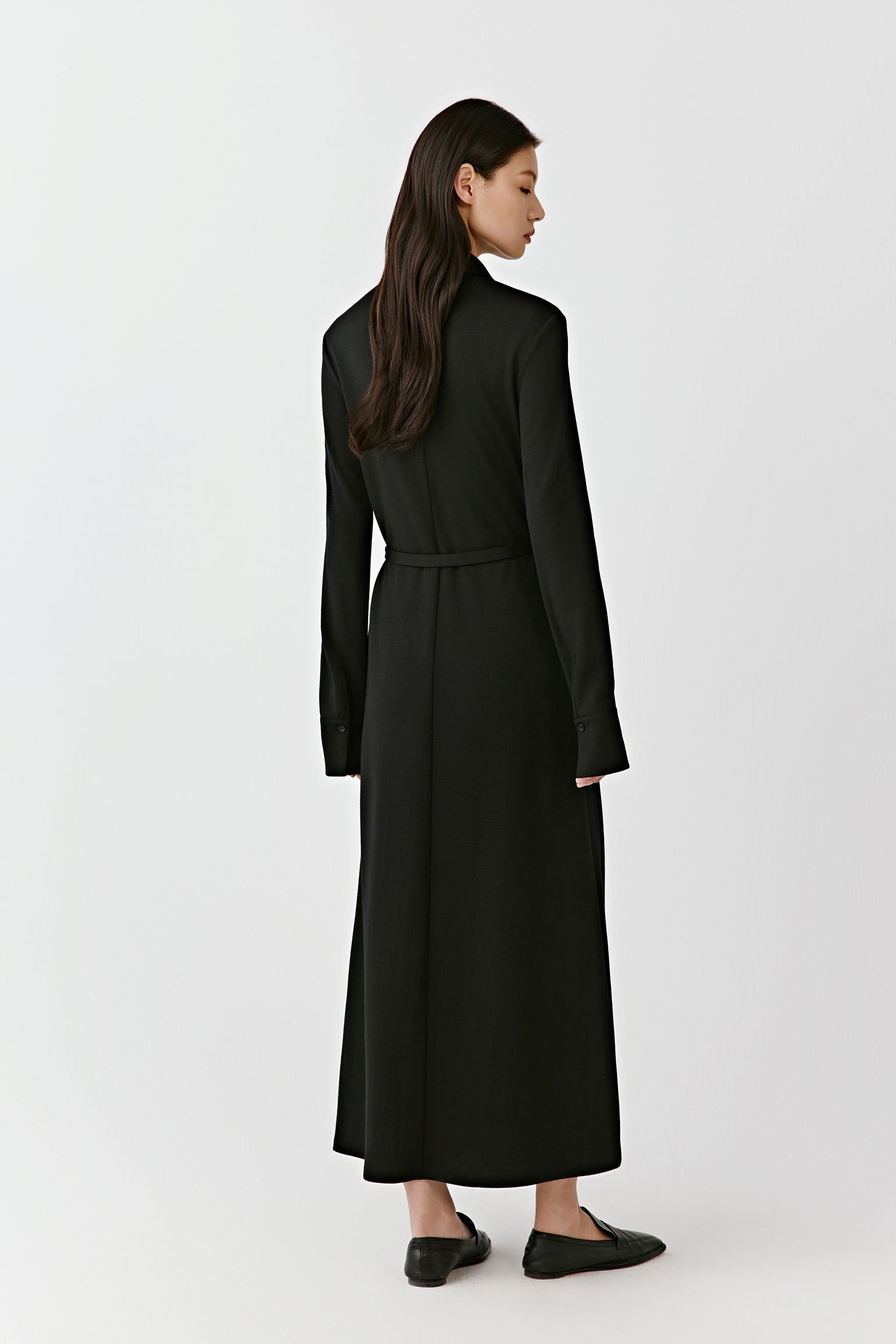 The profile view highlights the belt, which accentuates the waist and the dress's movement.