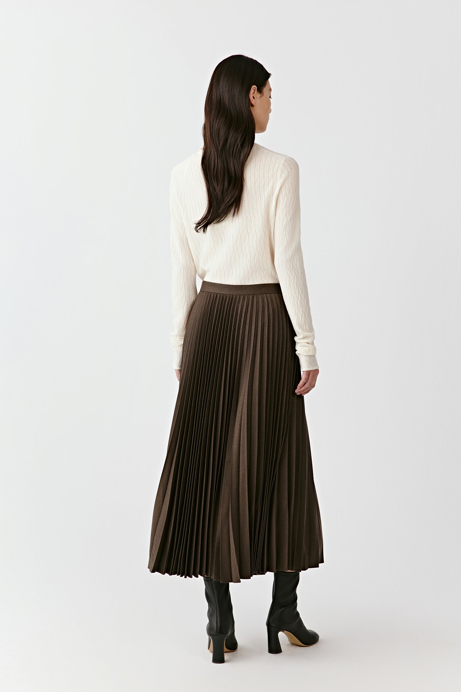 A side view captures the sharp pleats in motion and the natural swing of the skirt.