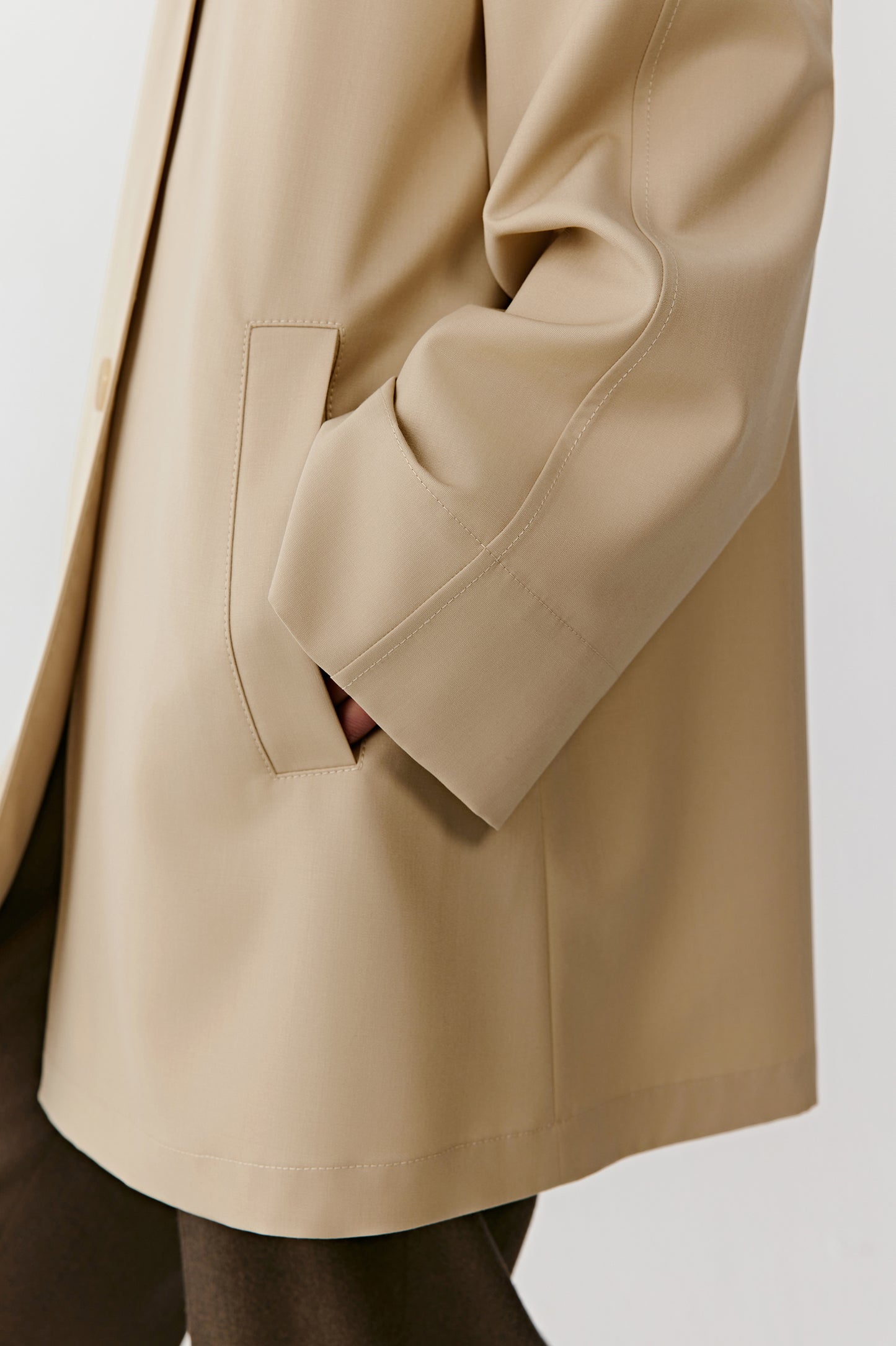 Side view showing the straight cut and fluid drape of the dense wool fabric.