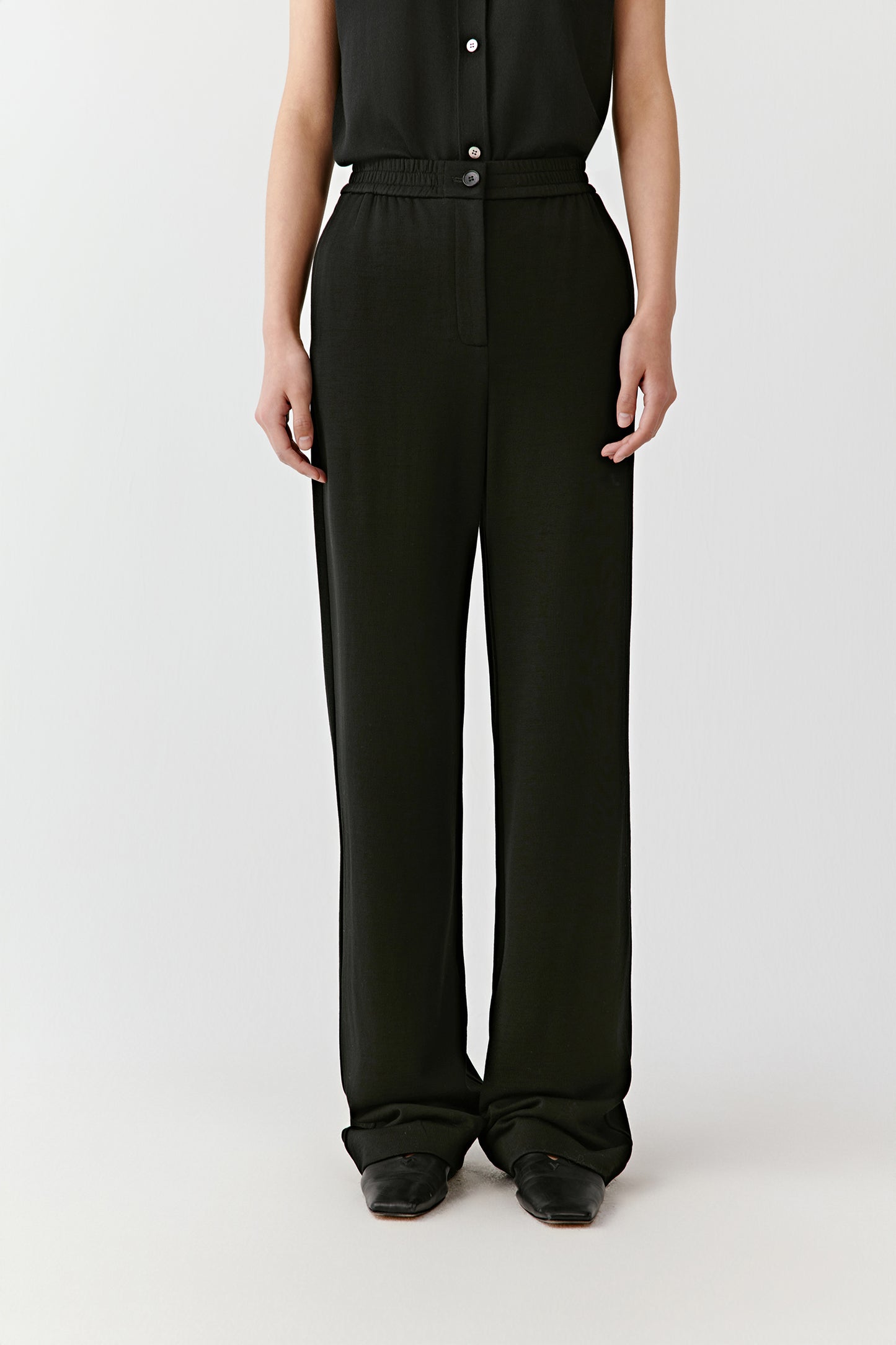 A mid-shot captures the soft fall of the trousers and the light texture of the wool.