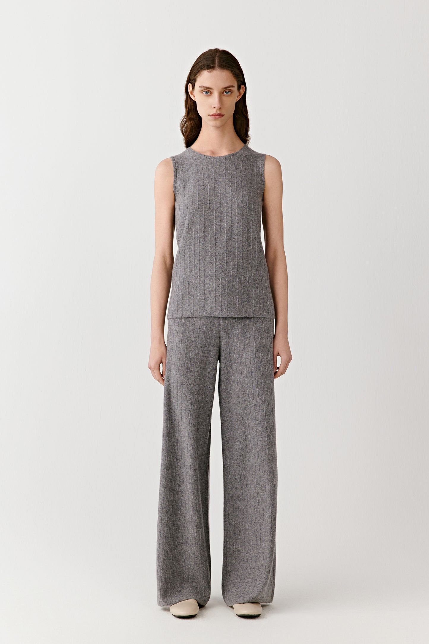 Full-length view showing the coordinated ribbed knit set in light grey wool and cashmere.