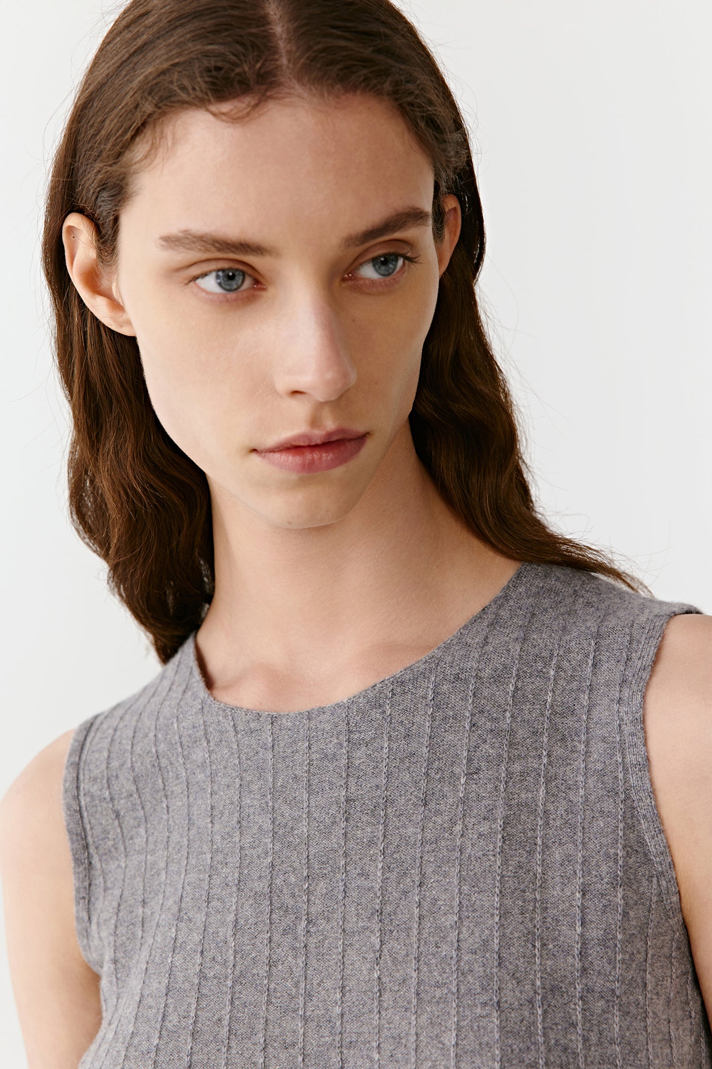 Close-up of the neckline and shoulder detailing of the light grey ribbed top.