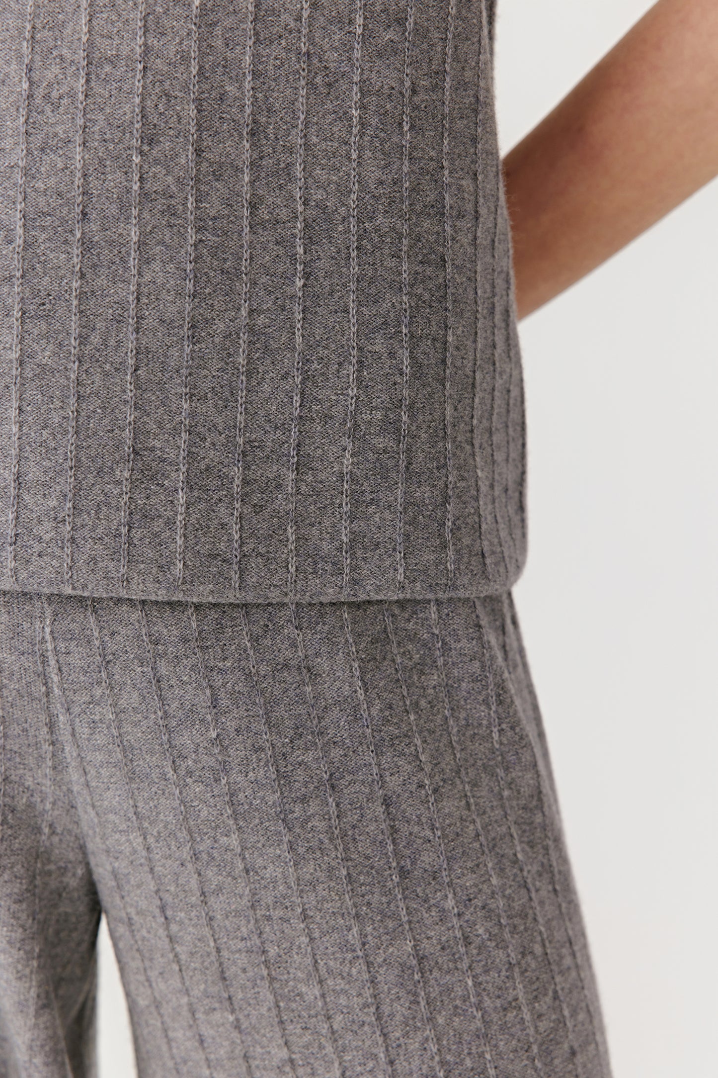 Detail of the ribbed texture and hemline in light grey wool and cashmere.