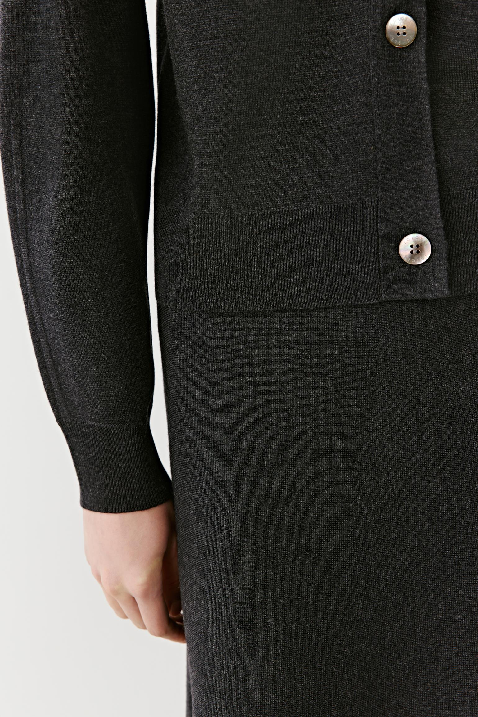 Detail of the front button fastening and ribbed hem of the black cashmere cardigan.