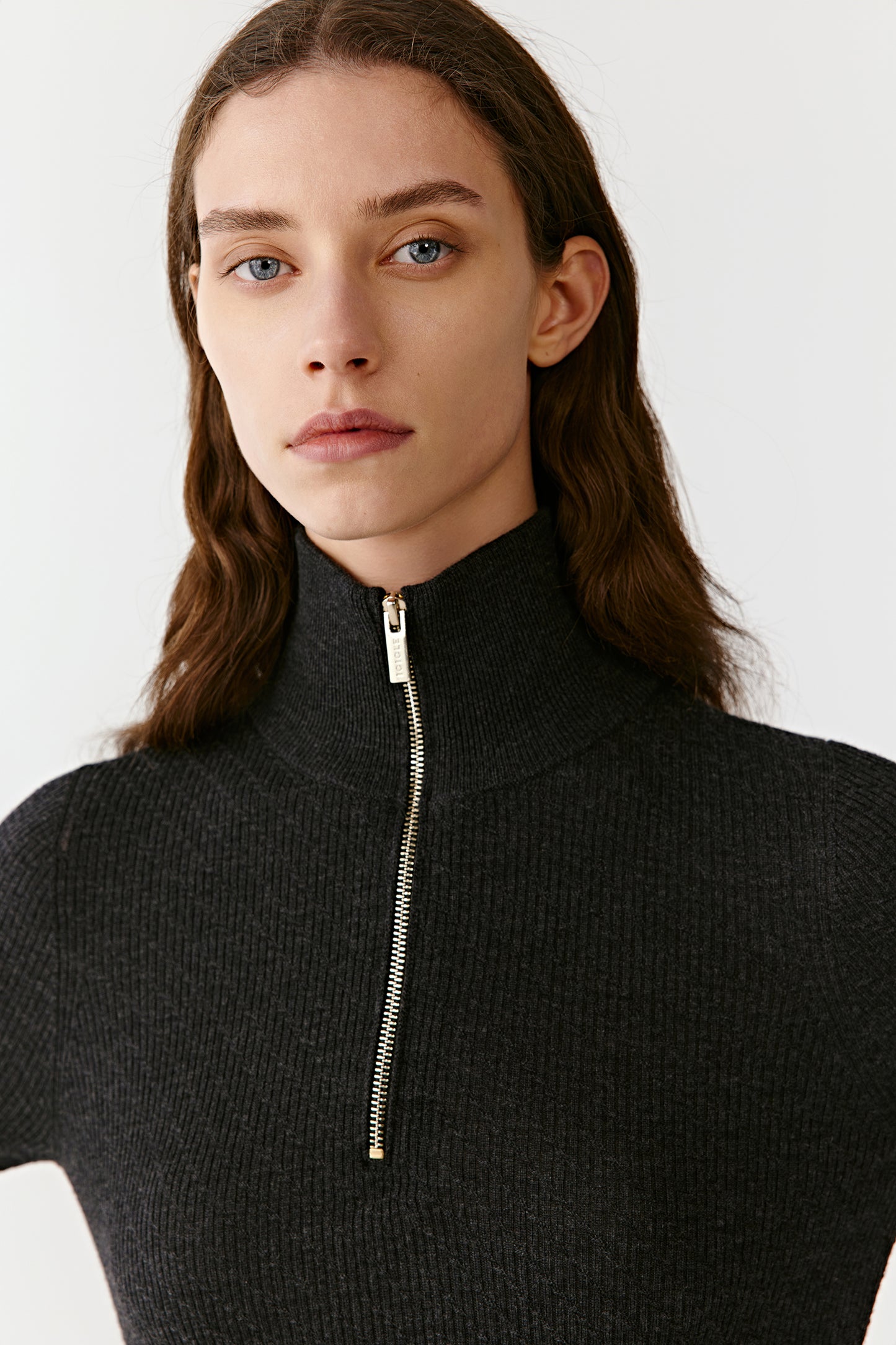 Close-up highlighting the metallic zip and fine ribbed texture of the black cashmere jumper.