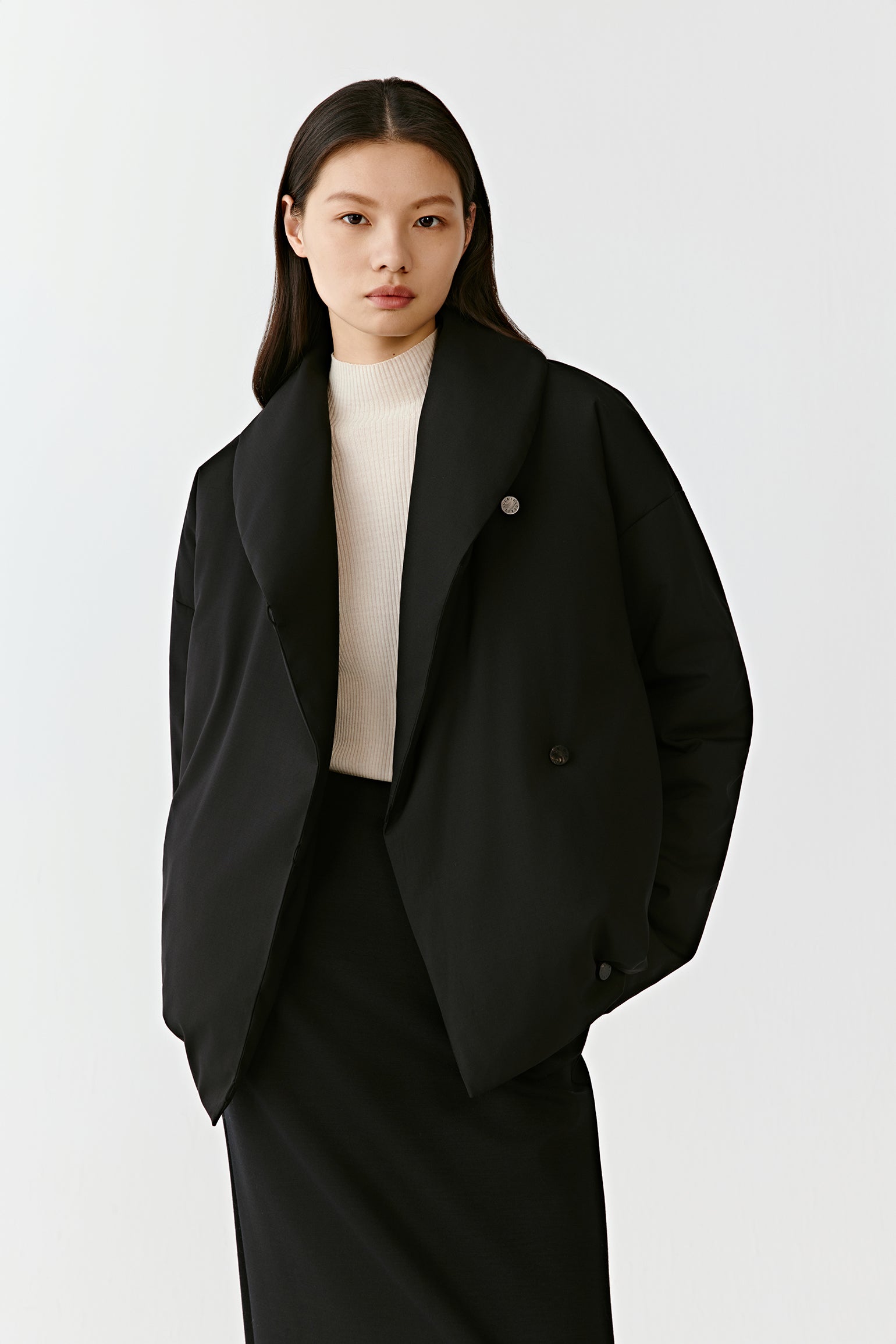 Back view showing the straight cut and smooth drape of the short black wool and cashmere coat.
