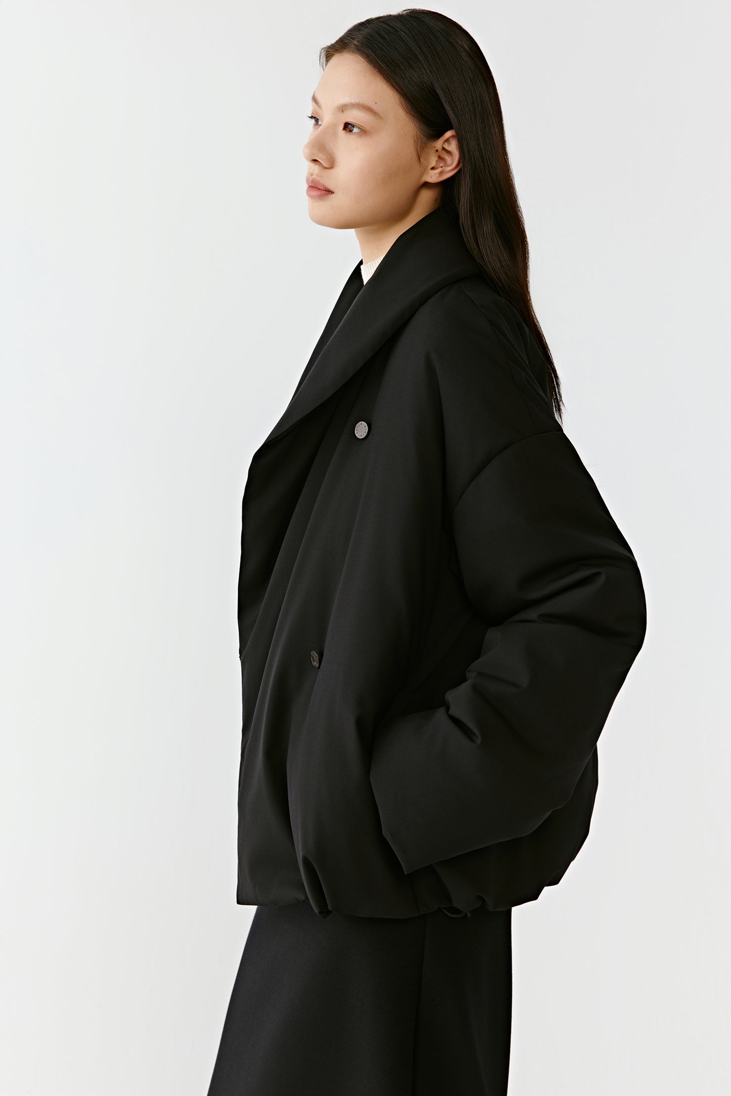 Side view highlighting the structured shoulders and fluid movement of the fabric.