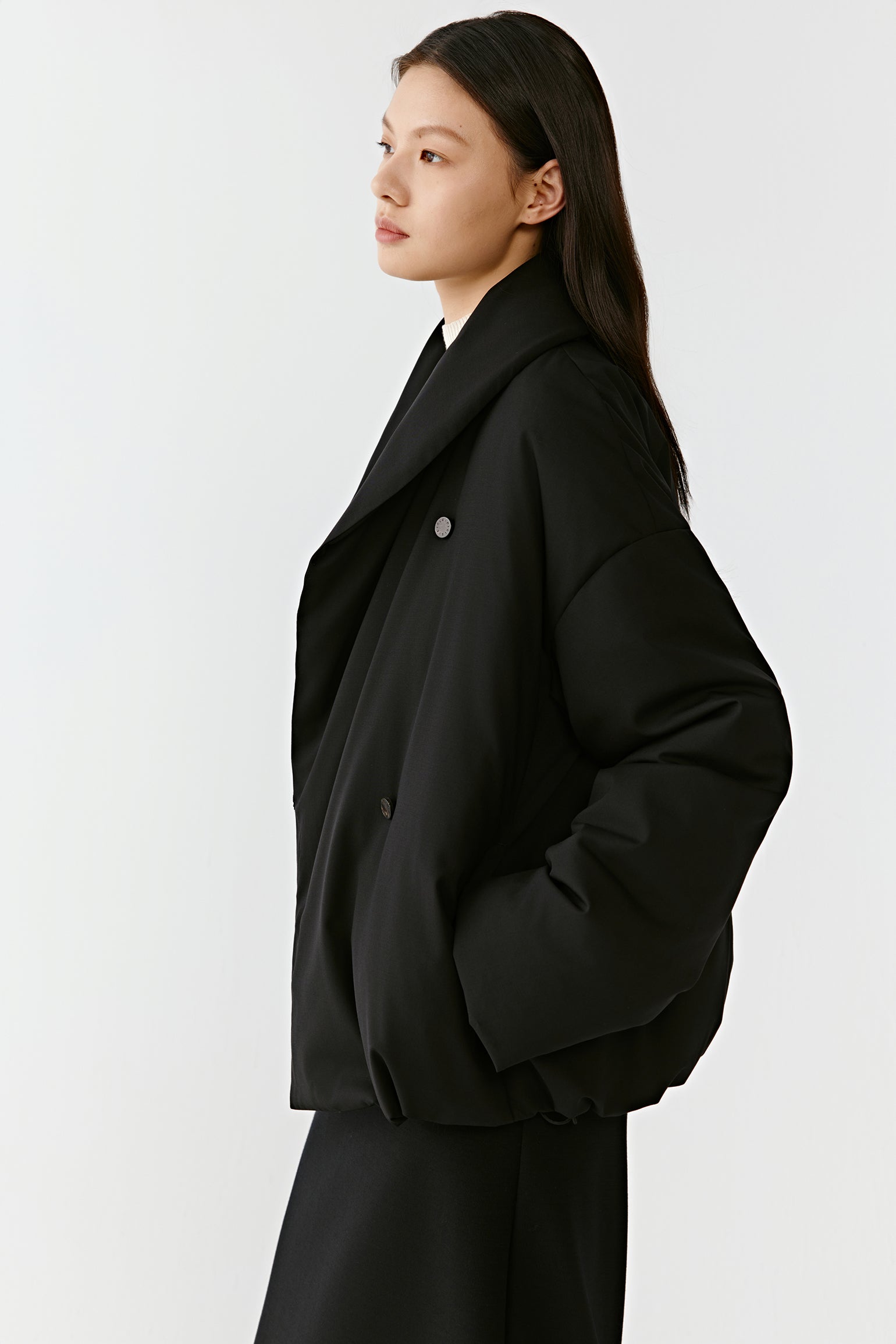 Side view highlighting the structured shoulders and fluid movement of the fabric.