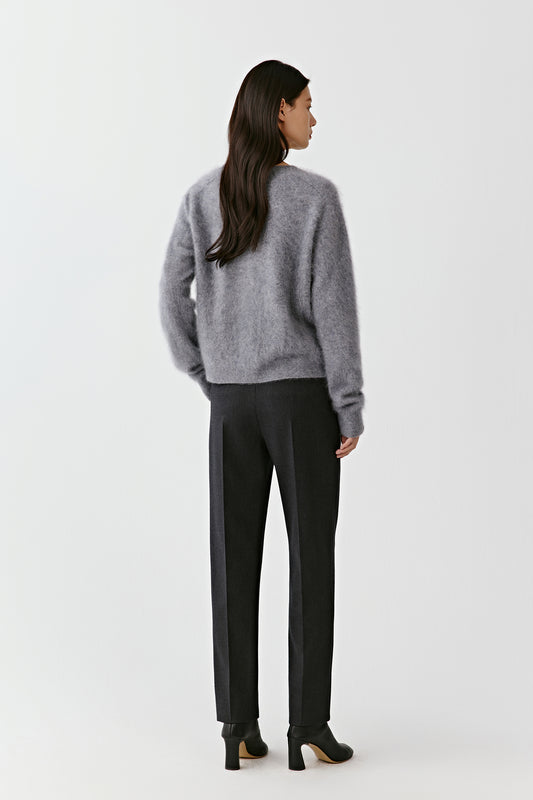 Back view of a woman wearing a grey cashmere cardigan with straight silhouette.