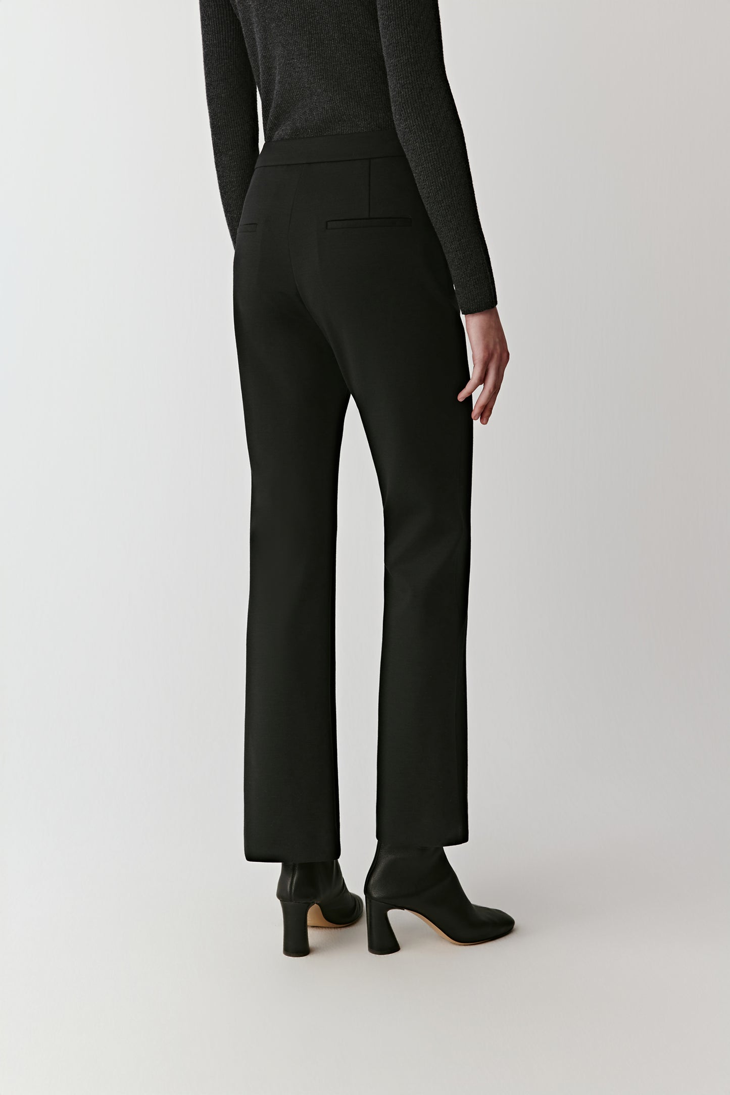 Back view revealing the neat welt pockets and the gentle flare at the hem.