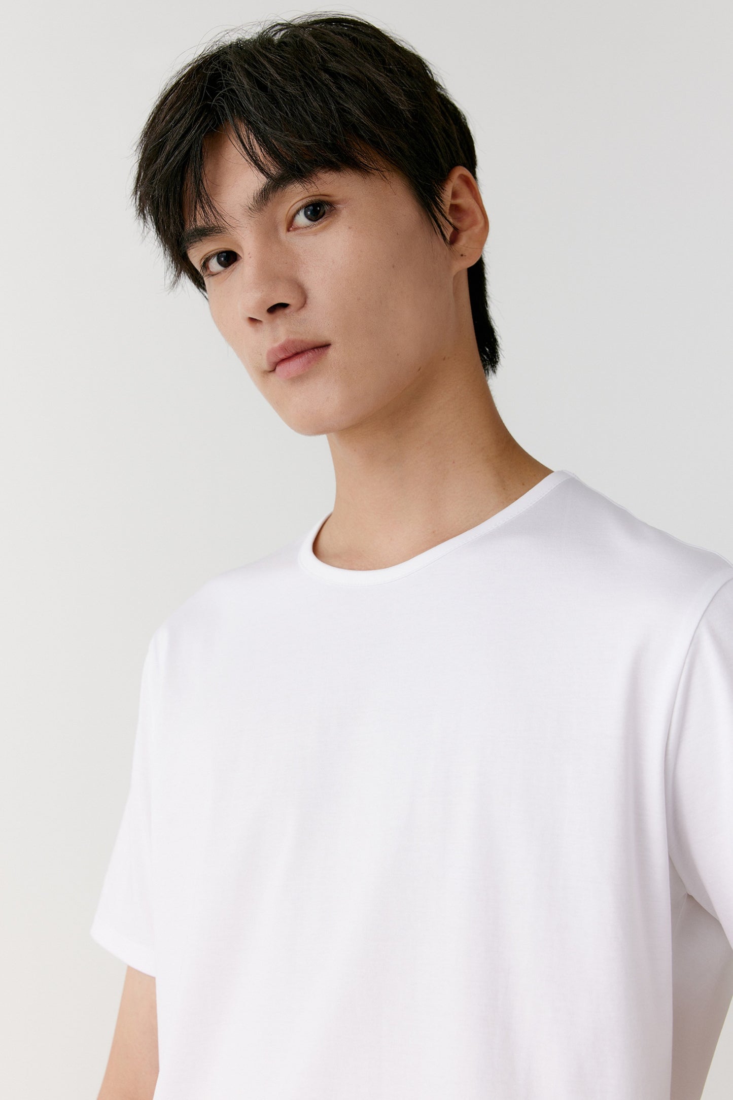 A close-up captures the fine weave and the even stitching at the neckline and sleeves under natural light.