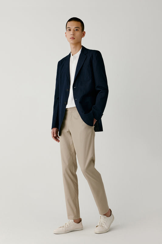 Full-length view showing the navy blazer with relaxed straight tailoring and light structure.