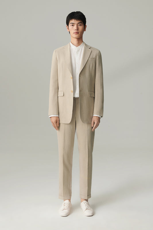 Man wearing a natural beige undyed linen blazer with straight relaxed fit, styled with matching linen trousers, full-length front view.