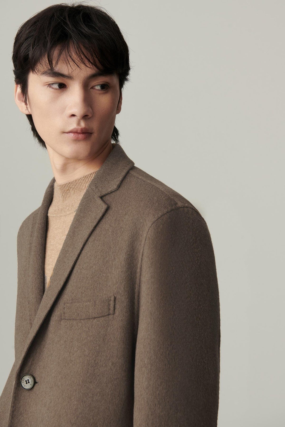 Close-up of the dark brown cashmere and wool coat, highlighting the notched lapels and smooth double-faced surface.