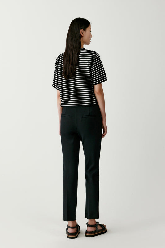The side view highlights the fluid fall of the legs and the tailored precision of the seams.