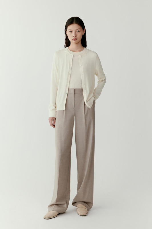 Full-length front view showing the cardigan styled with beige trousers. The cardigan falls naturally along the torso with a relaxed yet balanced structure.